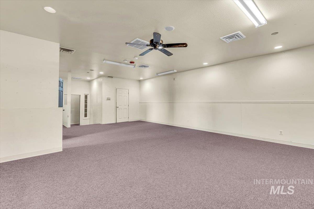 Carpeted empty room featuring a ceiling fan and recessed lighting
