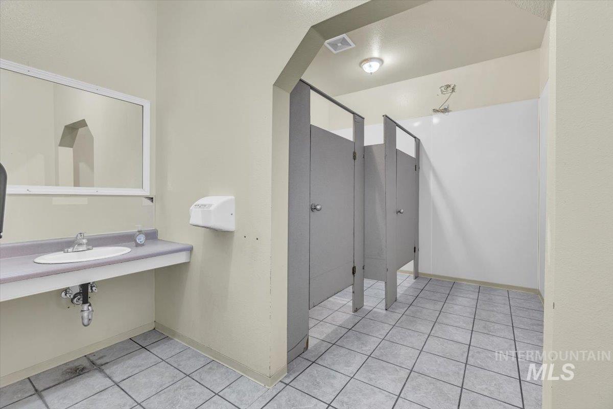 Bathroom with light tile patterned flooring and baseboards