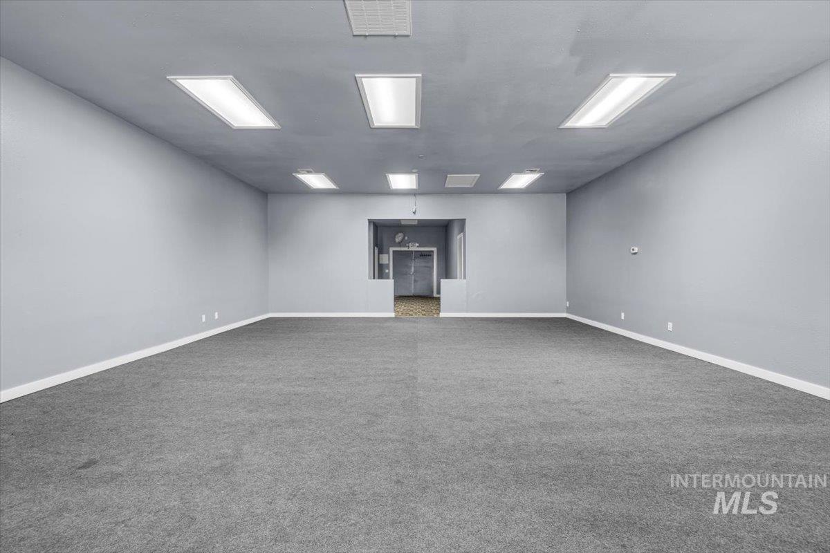 Carpeted empty room featuring baseboards