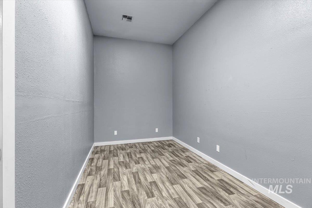 Empty room featuring wood finished floors and a textured wall