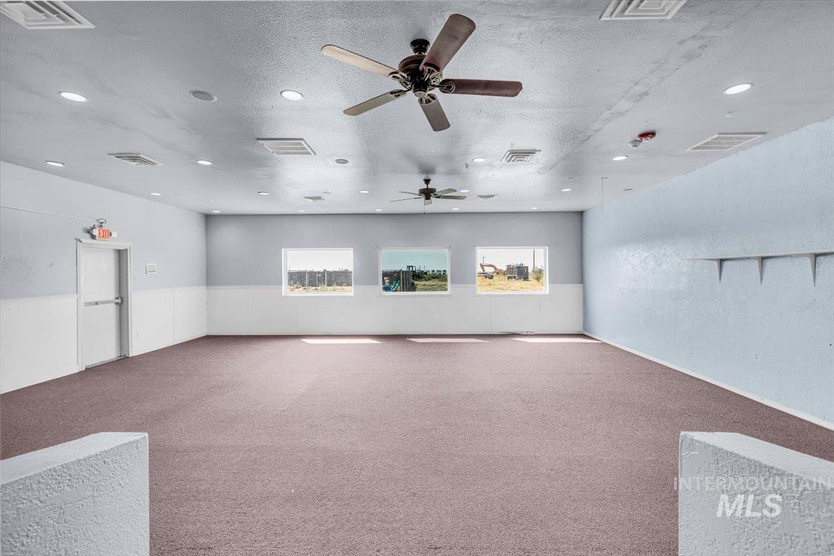 Spare room with carpet floors, a textured ceiling, a ceiling fan, recessed lighting, and a textured wall