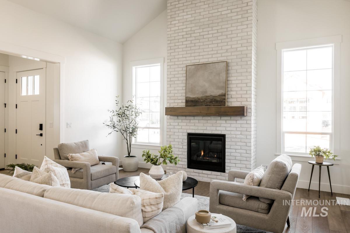 Living room featuring lofted ceiling, wood finished floors, and a fireplace