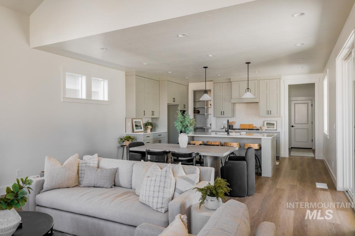 Living room with light wood finished floors and recessed lighting
