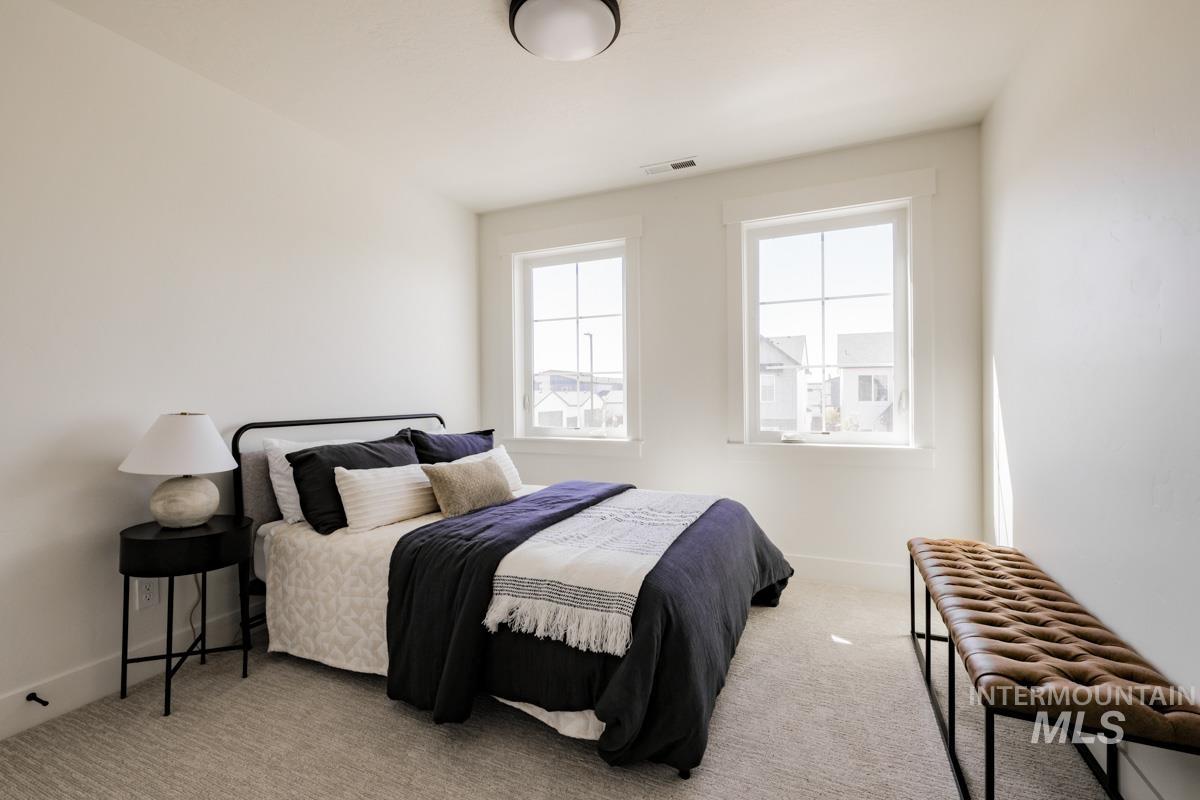 Bedroom with light carpet and baseboards