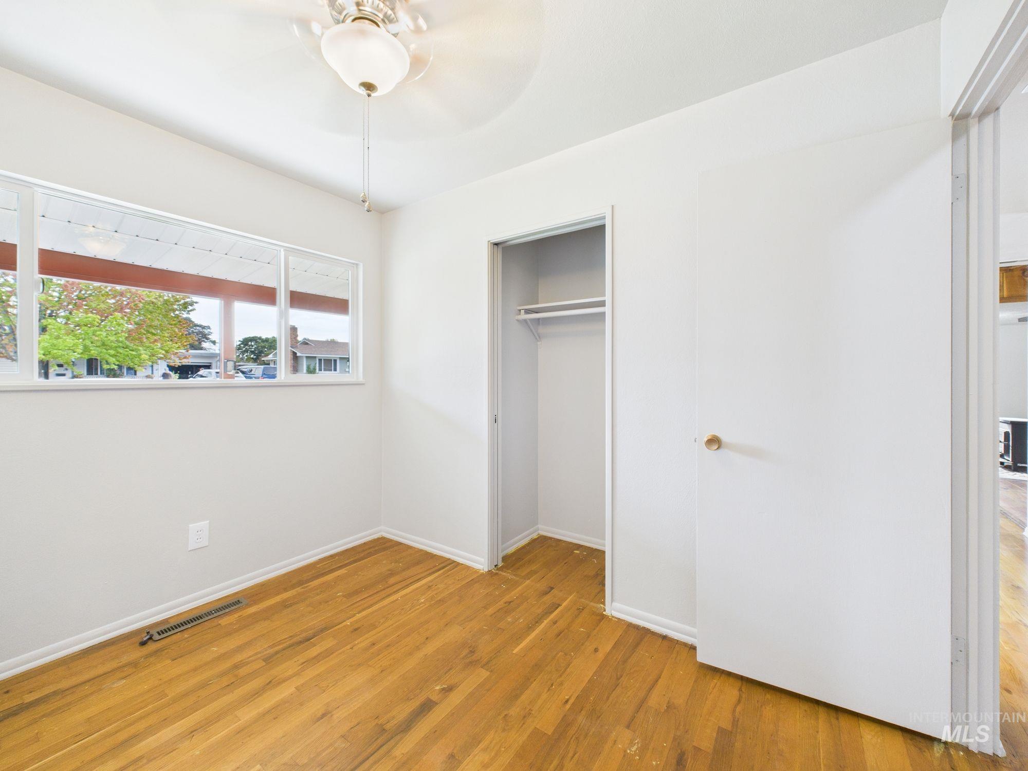 Unfurnished bedroom featuring light wood-style flooring, a closet, and a ceiling fan