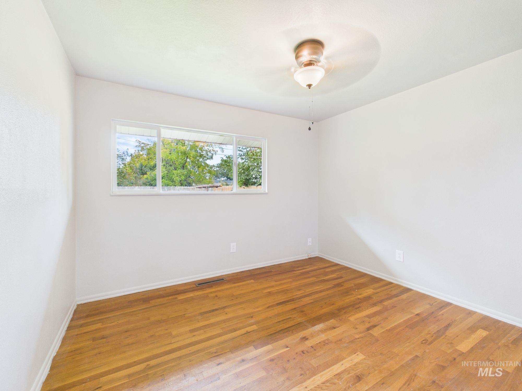 Unfurnished room with light wood-style flooring and ceiling fan
