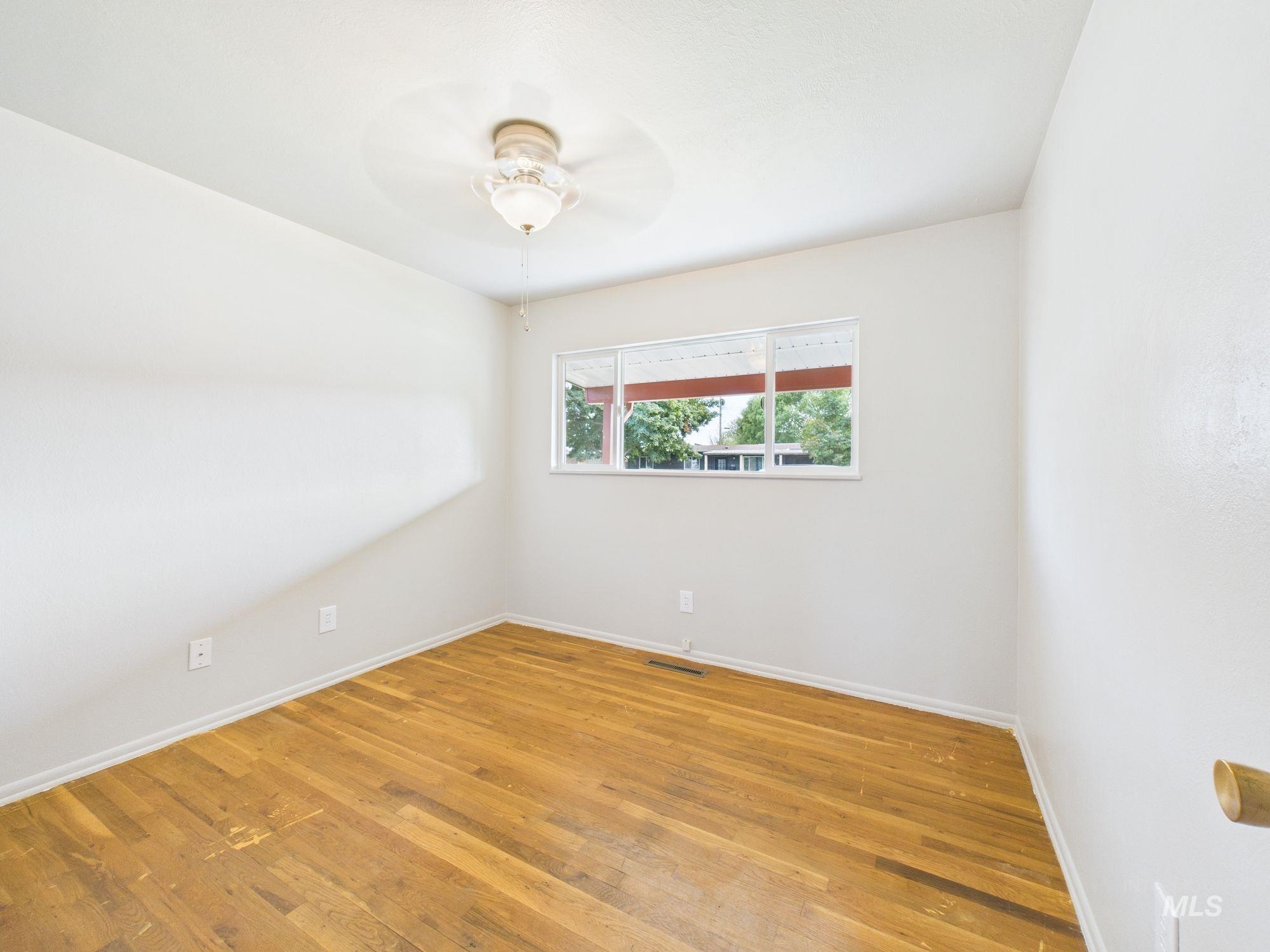 Spare room with light wood finished floors and ceiling fan