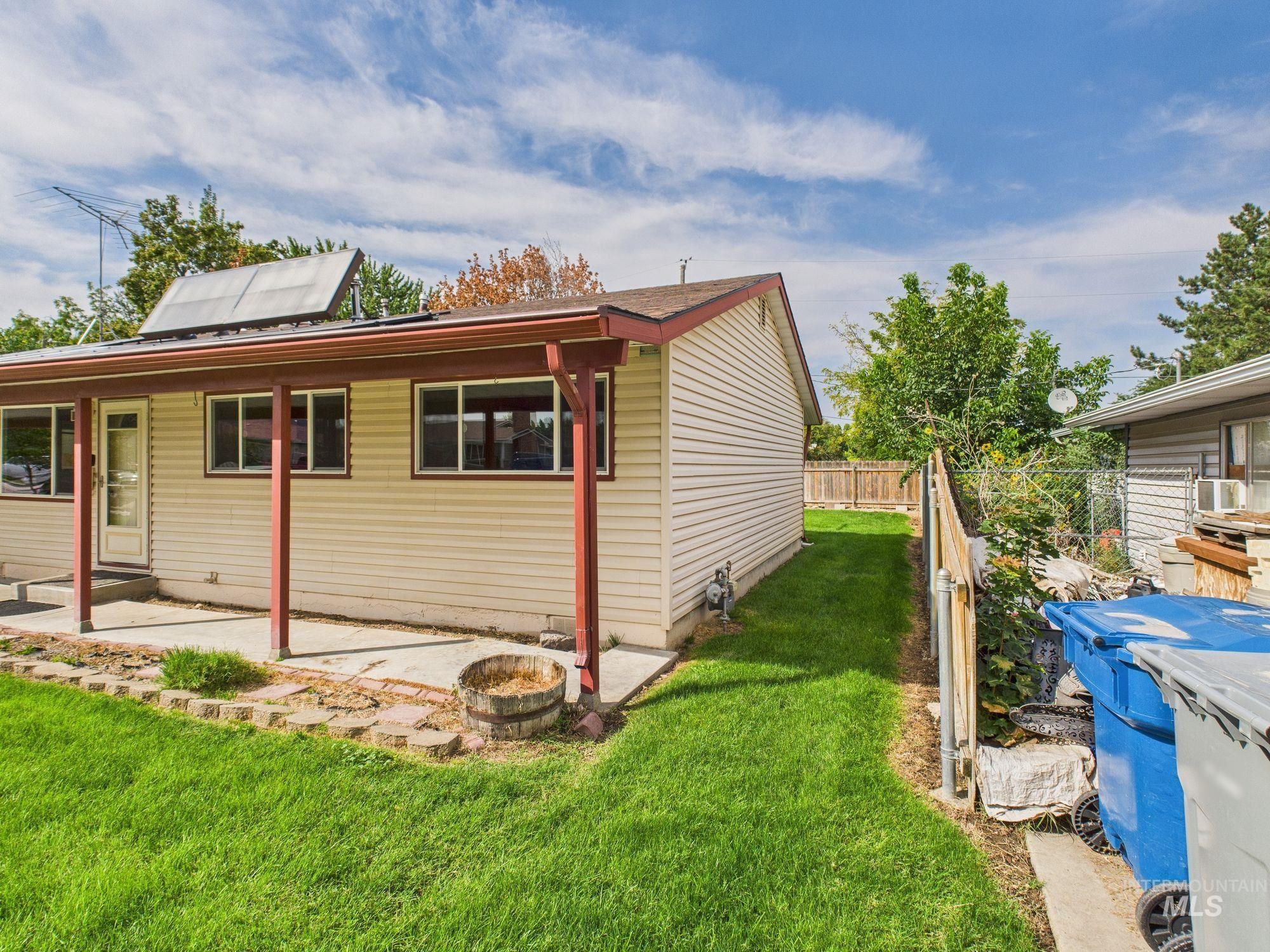 View of home's exterior with a patio and roof mounted solar panels