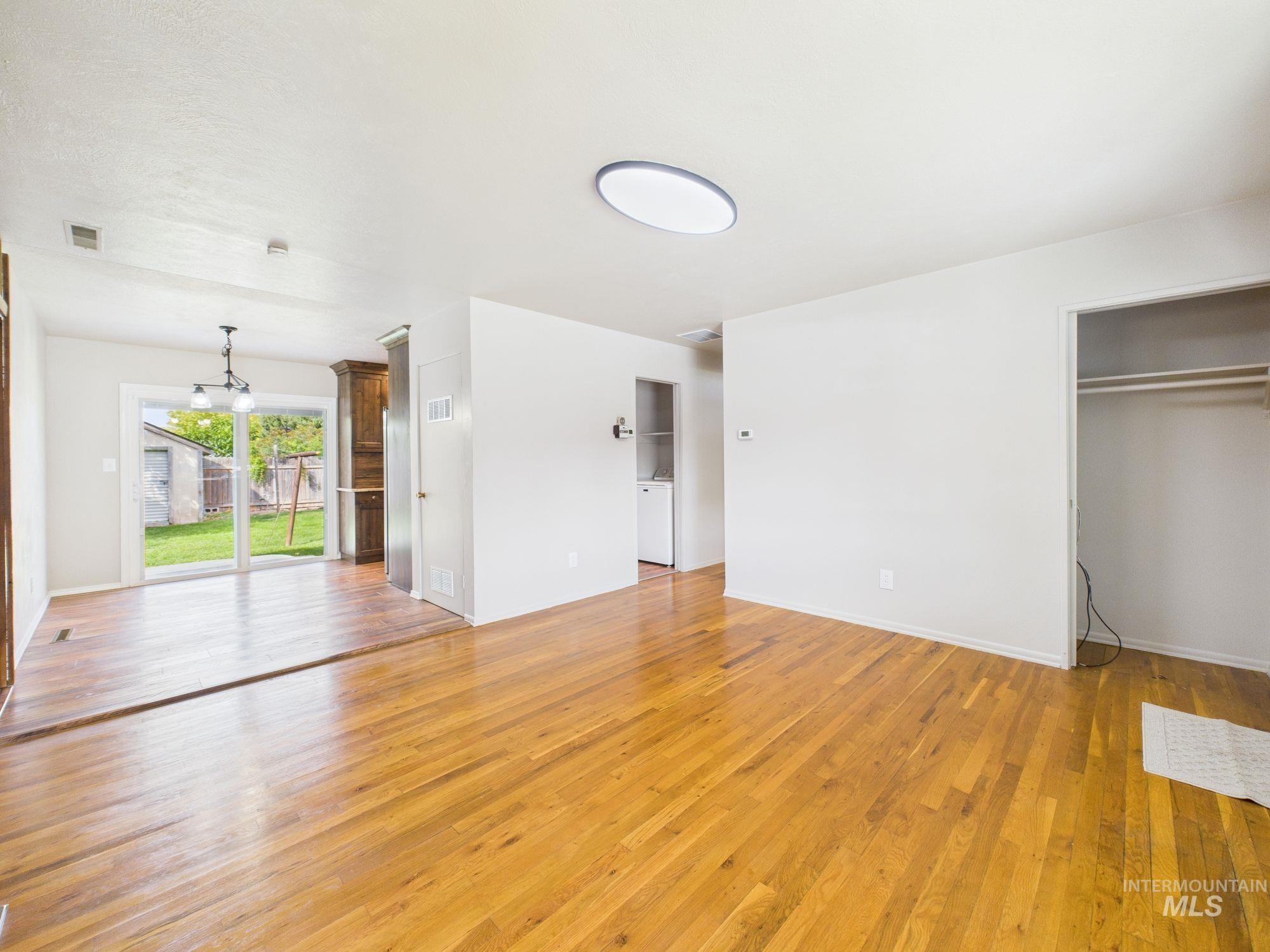 Unfurnished living room with light wood-type flooring and baseboards