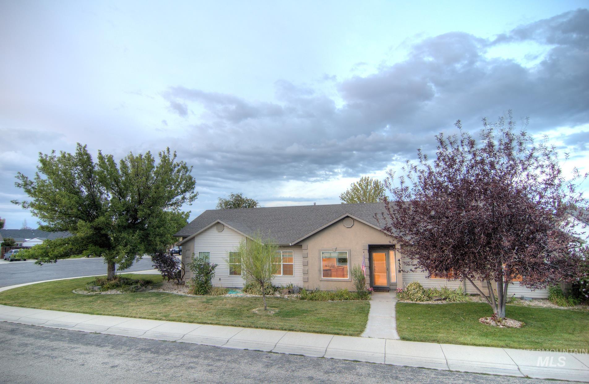 View of front of house featuring a front lawn and a shingled roof