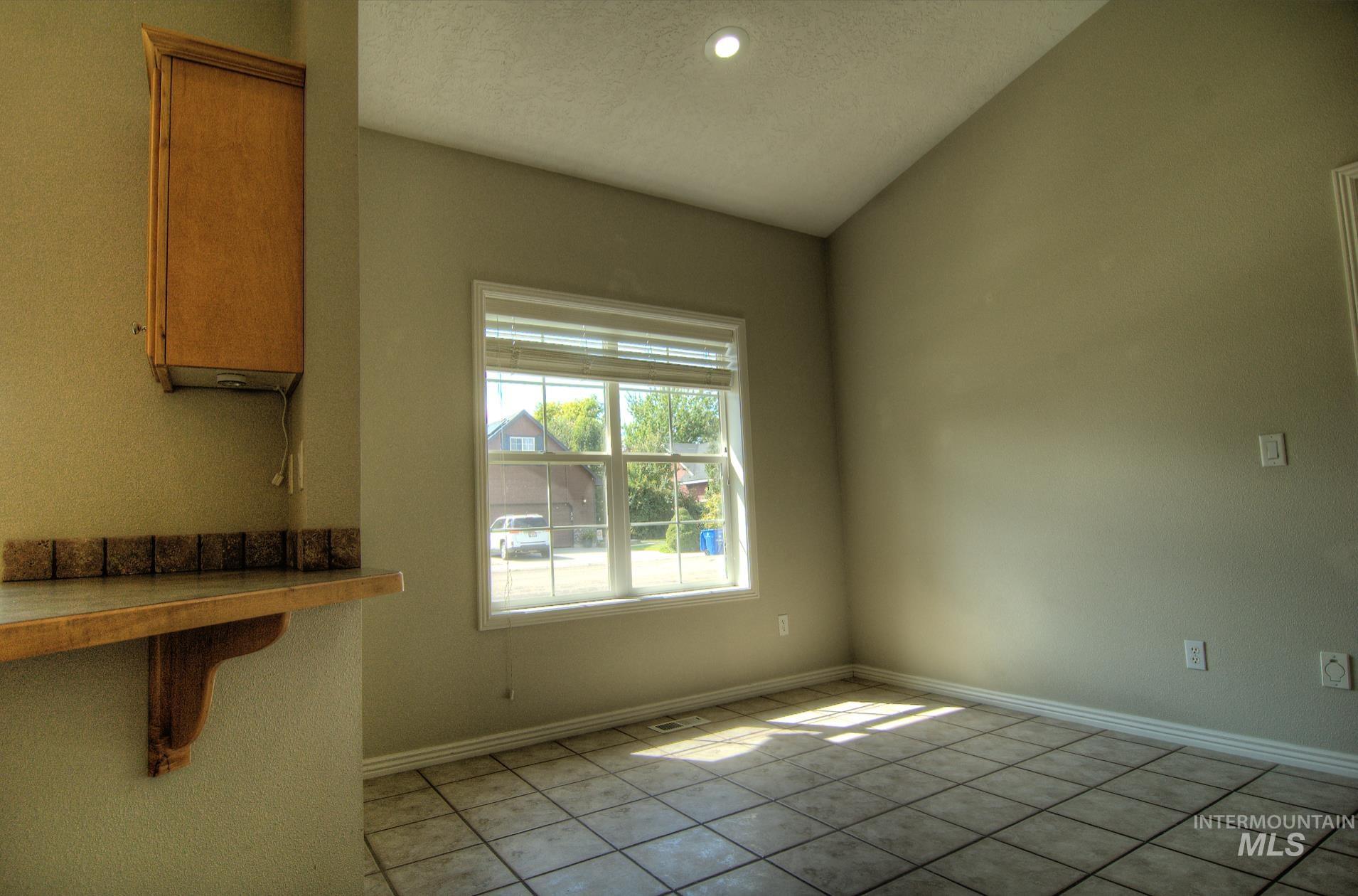 Unfurnished dining area featuring light tile patterned floors, lofted ceiling, a textured ceiling, and recessed lighting