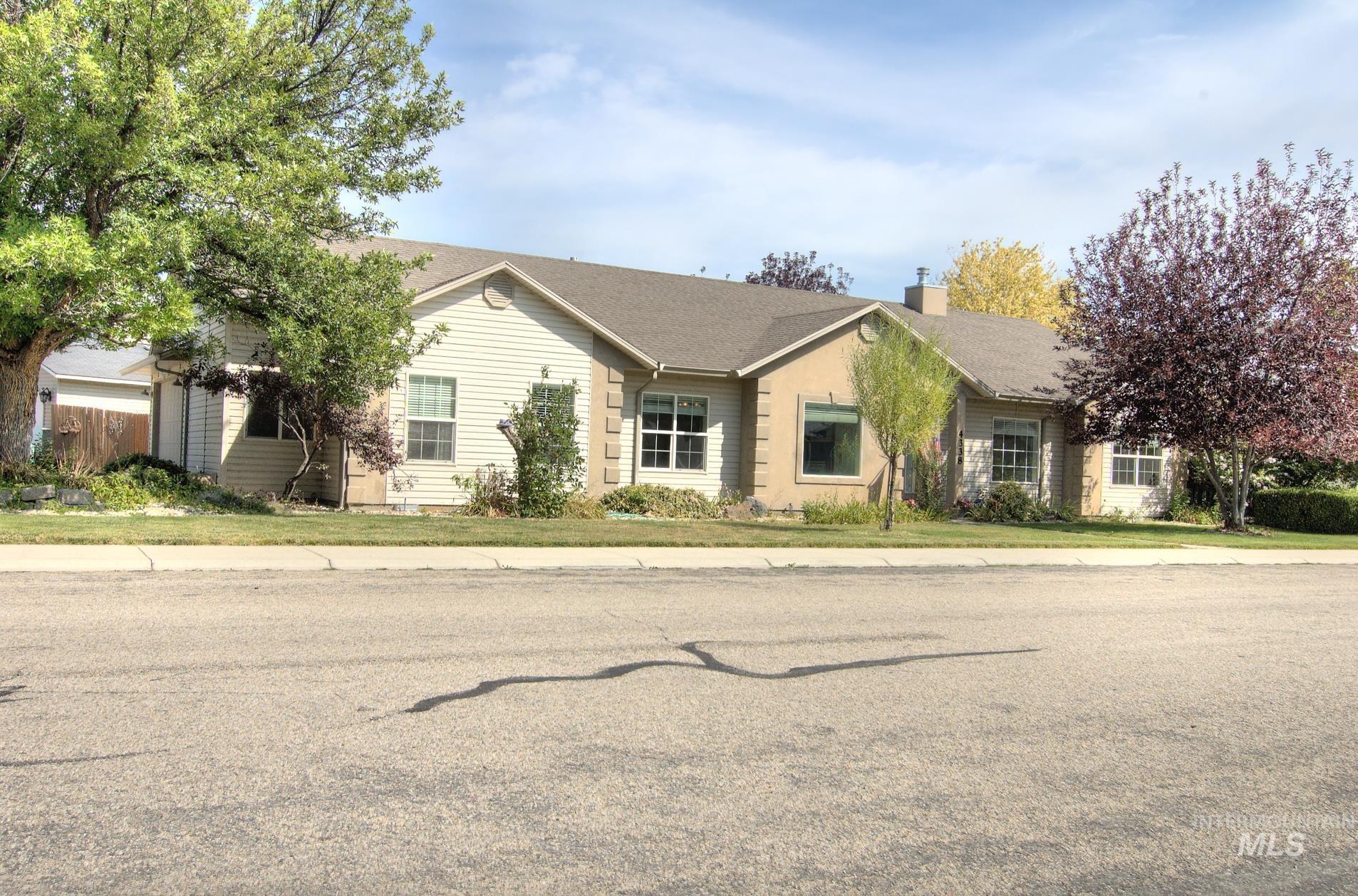 Ranch-style home with a chimney and roof with shingles