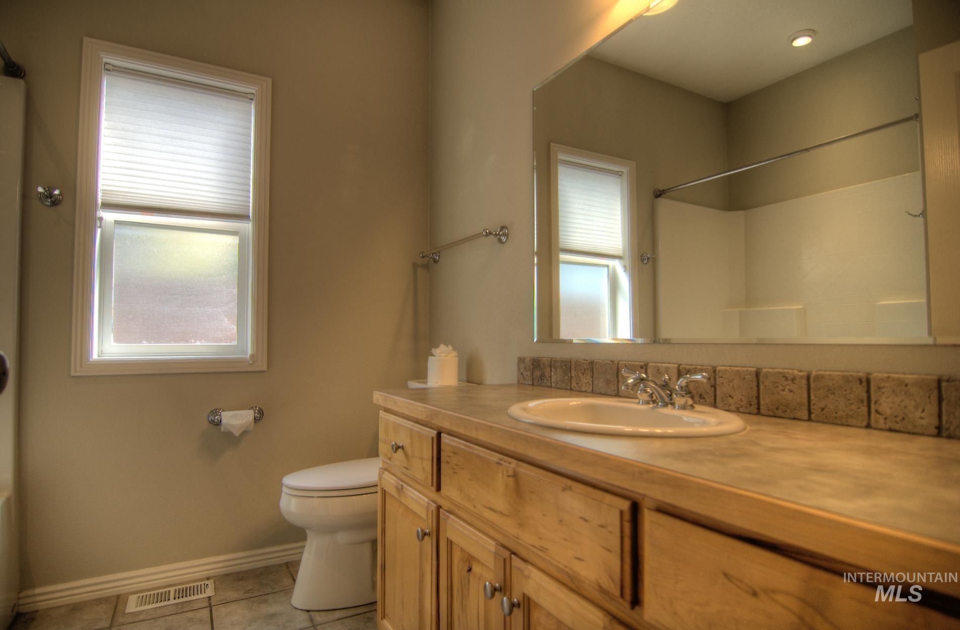 Full bath featuring vanity and light tile patterned floors