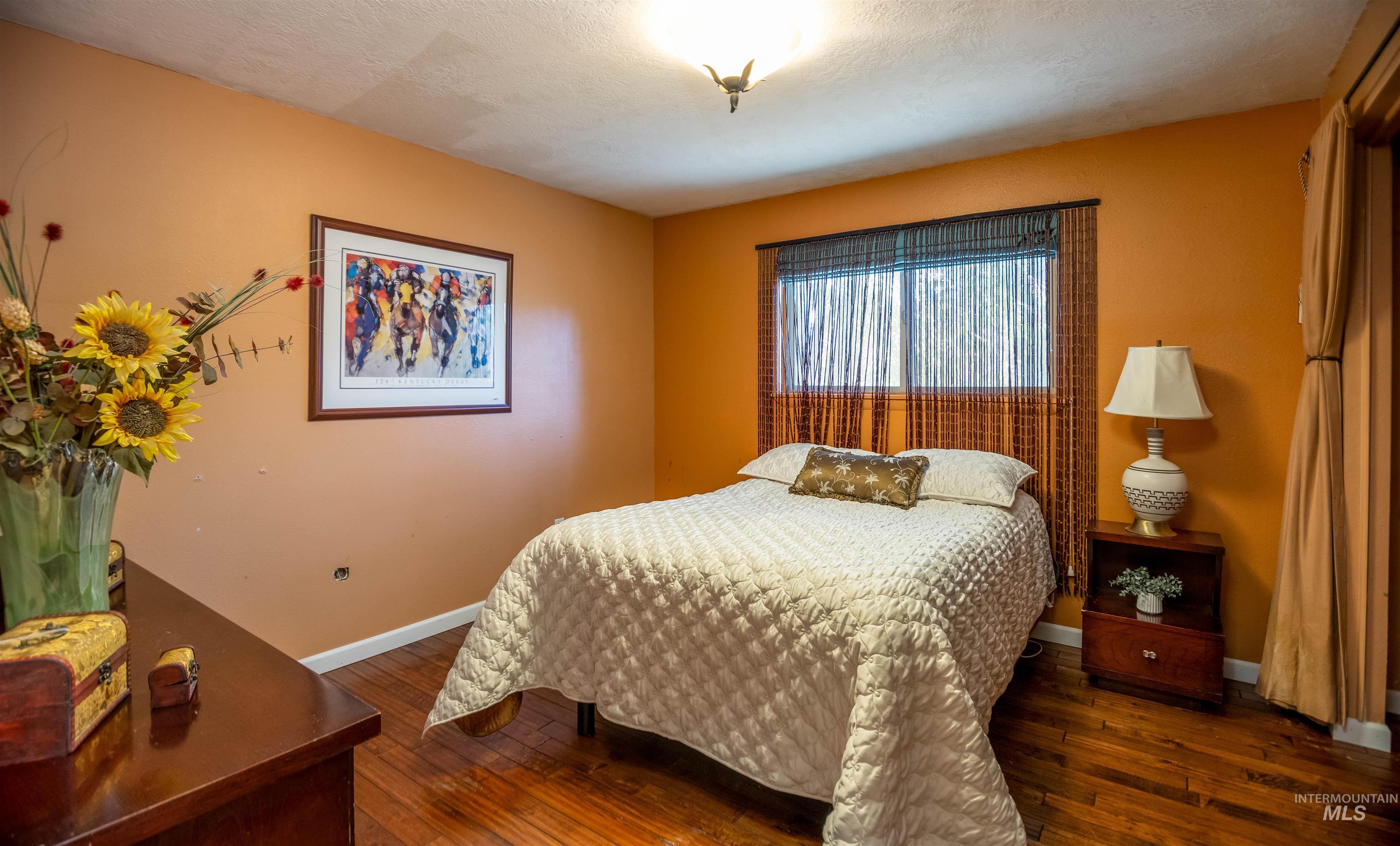 Bedroom with dark wood-style flooring and a textured ceiling