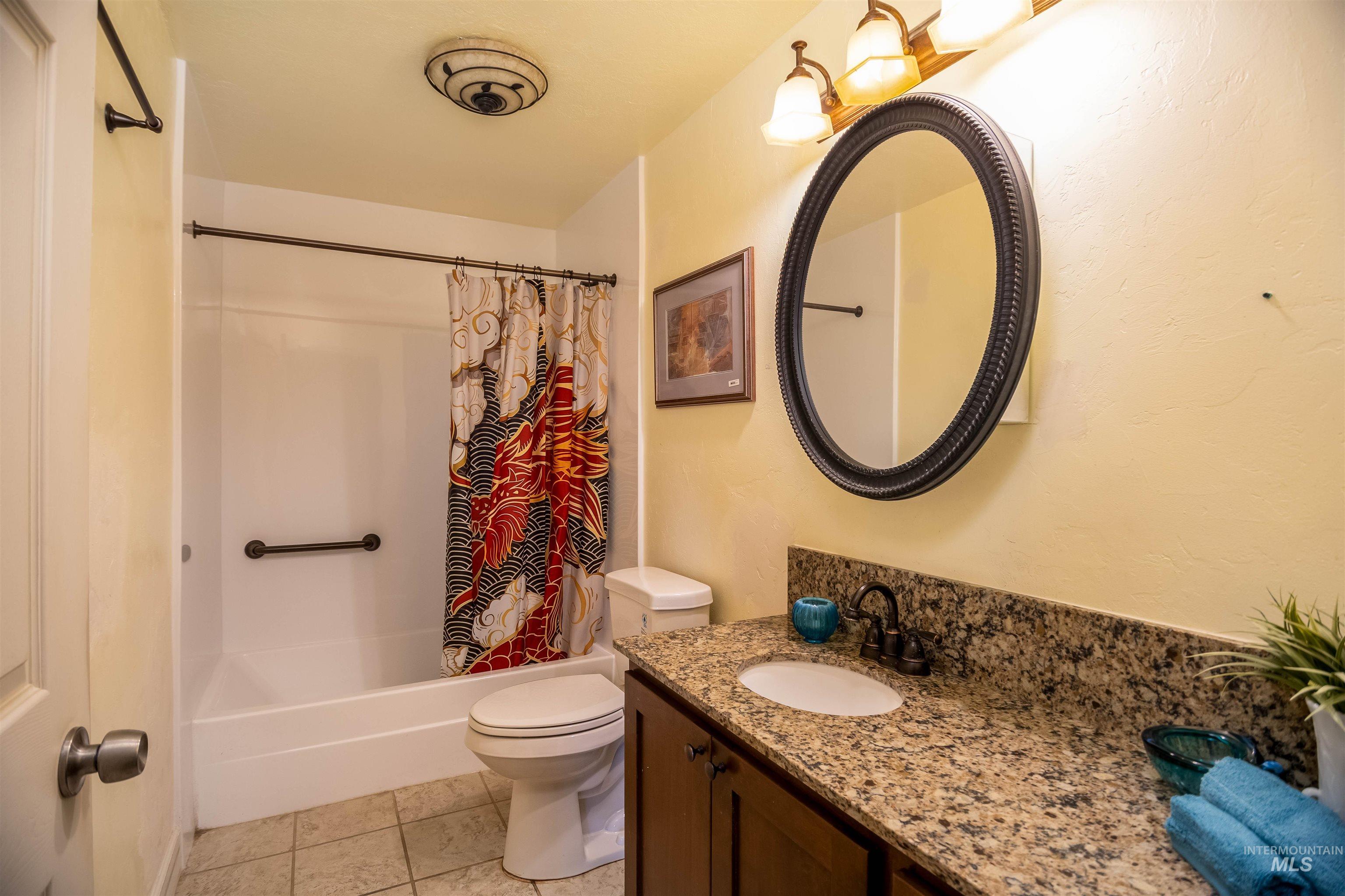 Full bath with shower / tub combo, light tile patterned flooring, and vanity