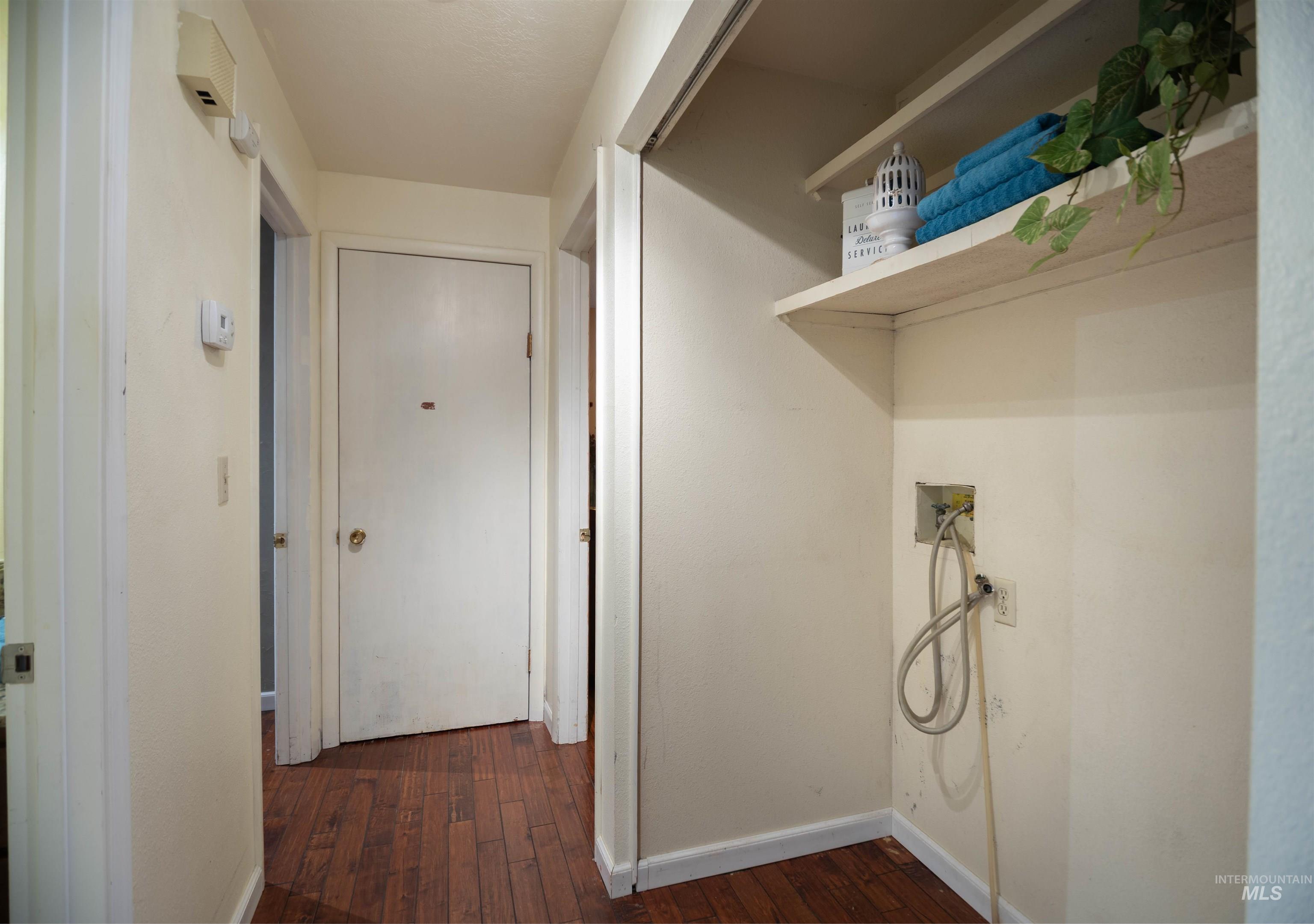 Laundry area featuring dark wood finished floors and hookup for a washing machine