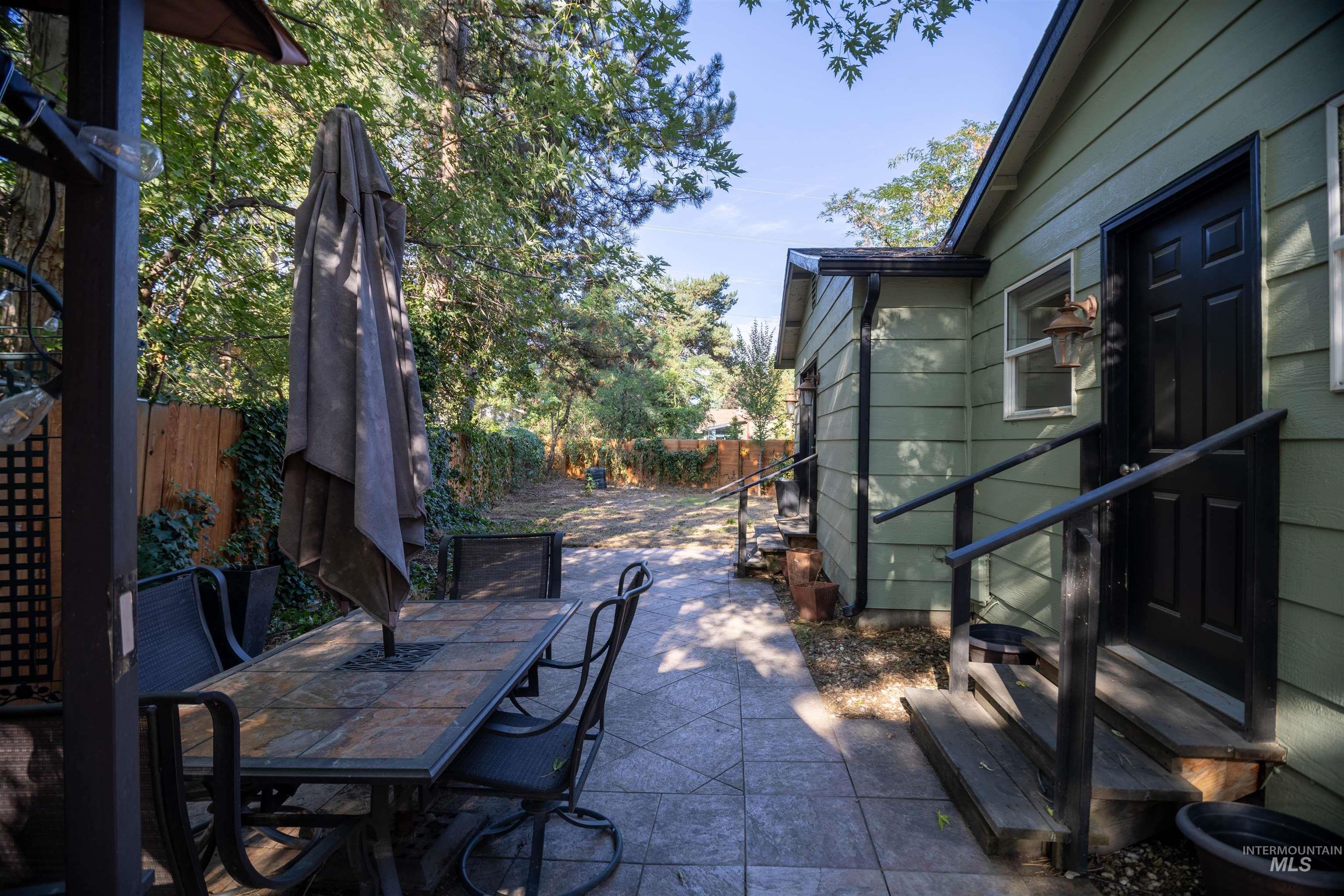 Fenced backyard with entry steps, a patio area, and outdoor dining space