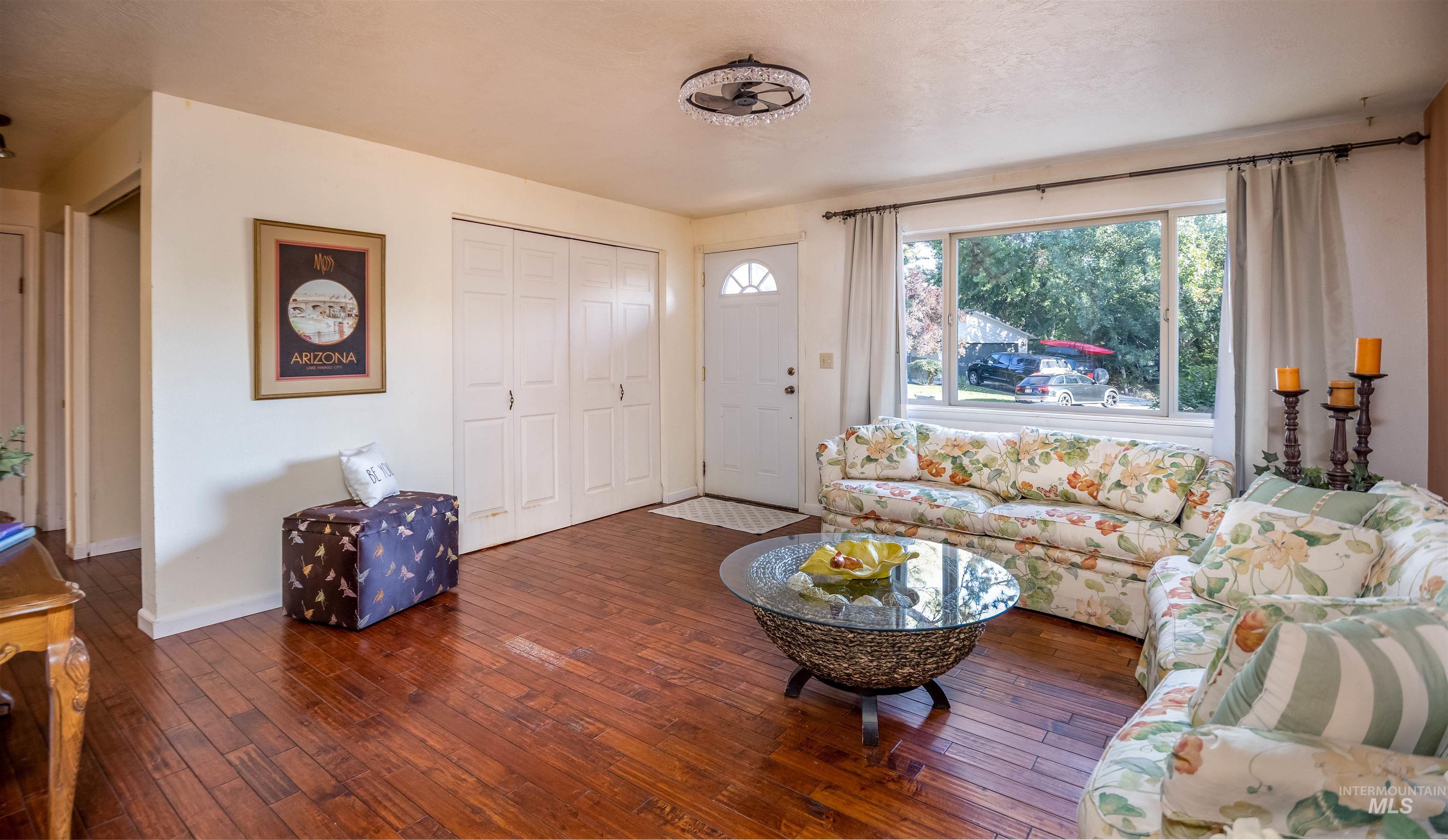 Living area with dark wood-type flooring and baseboards
