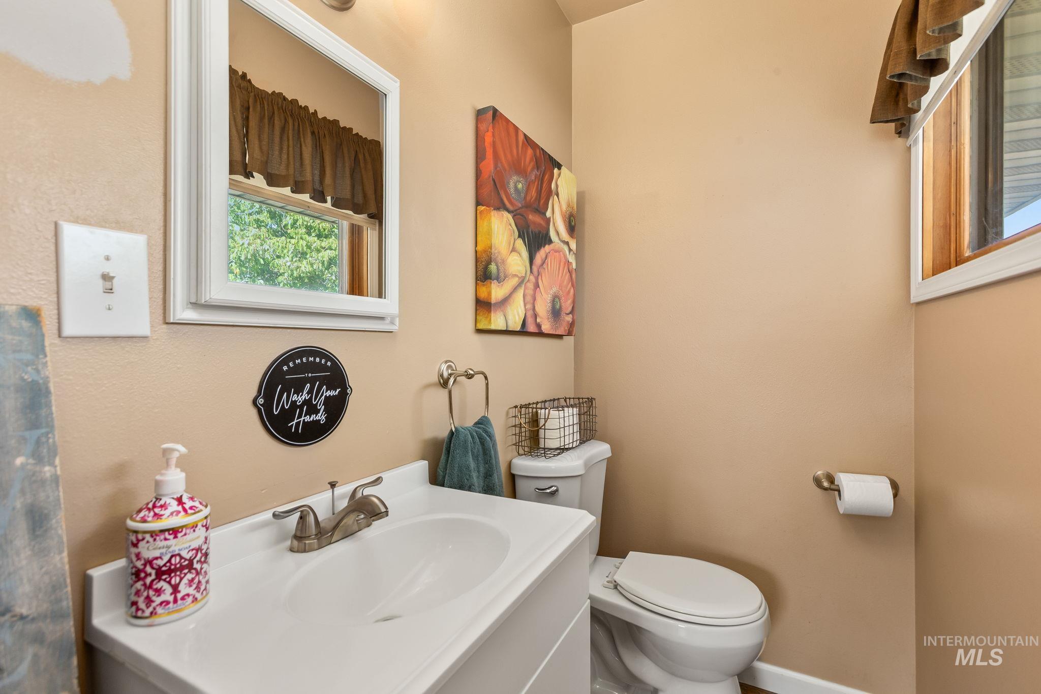 Half bathroom featuring vanity and toilet