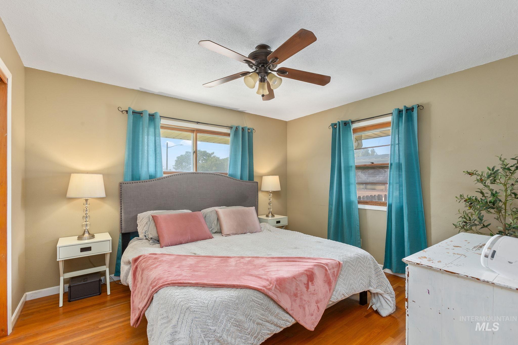 Bedroom featuring wood finished floors, ceiling fan, and a textured ceiling