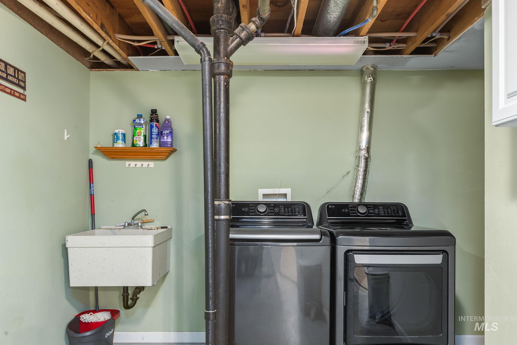 Laundry area with washer and dryer and baseboards