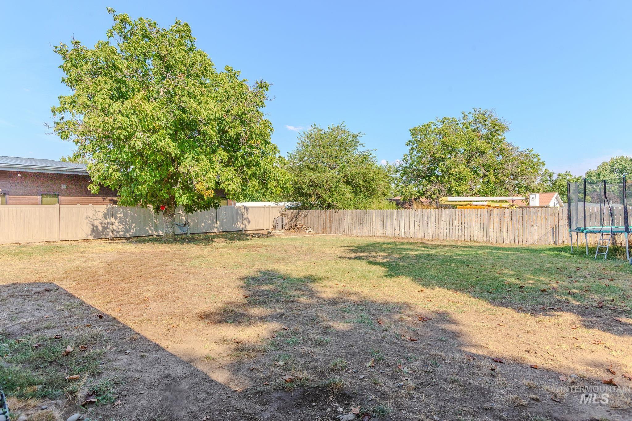 Fenced backyard with a trampoline
