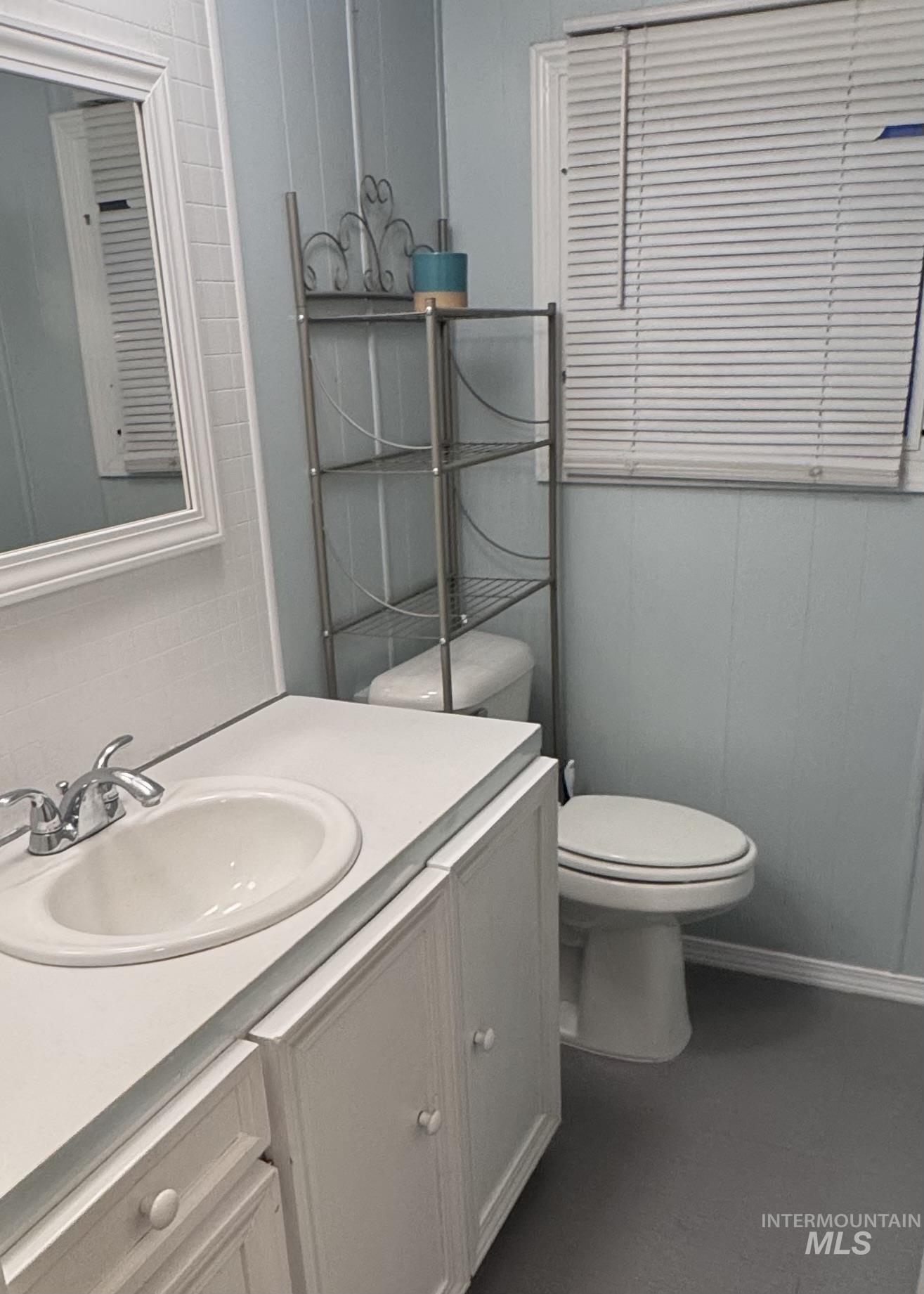 Half bathroom featuring vanity and toilet