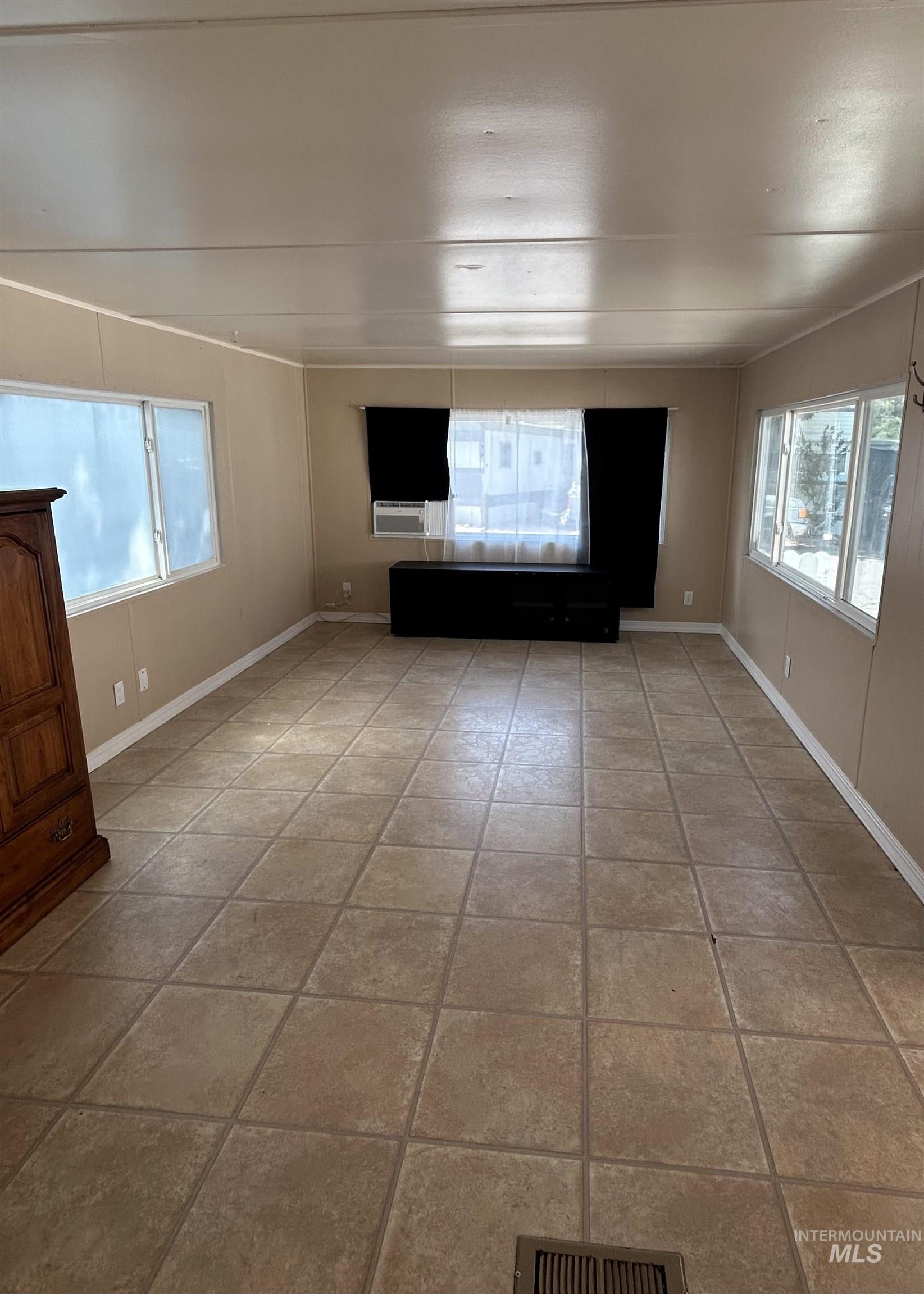 Unfurnished living room featuring baseboards