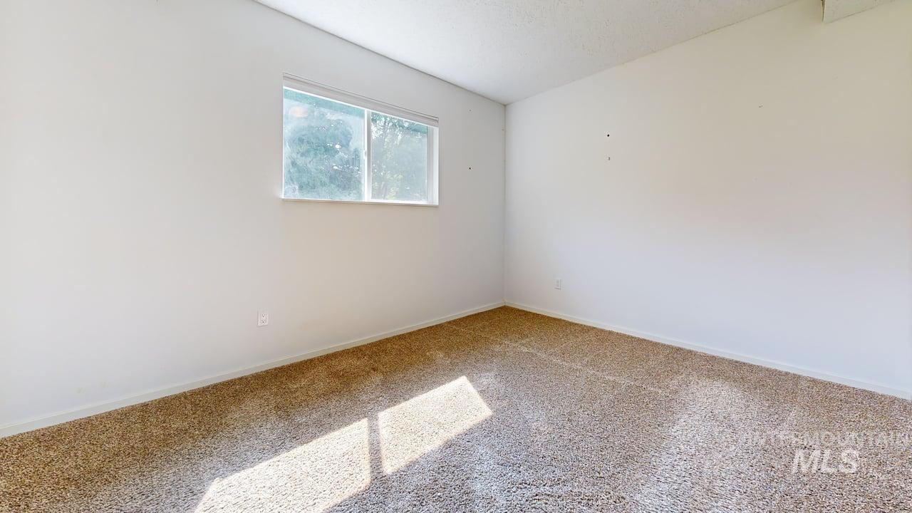 Carpeted empty room with baseboards