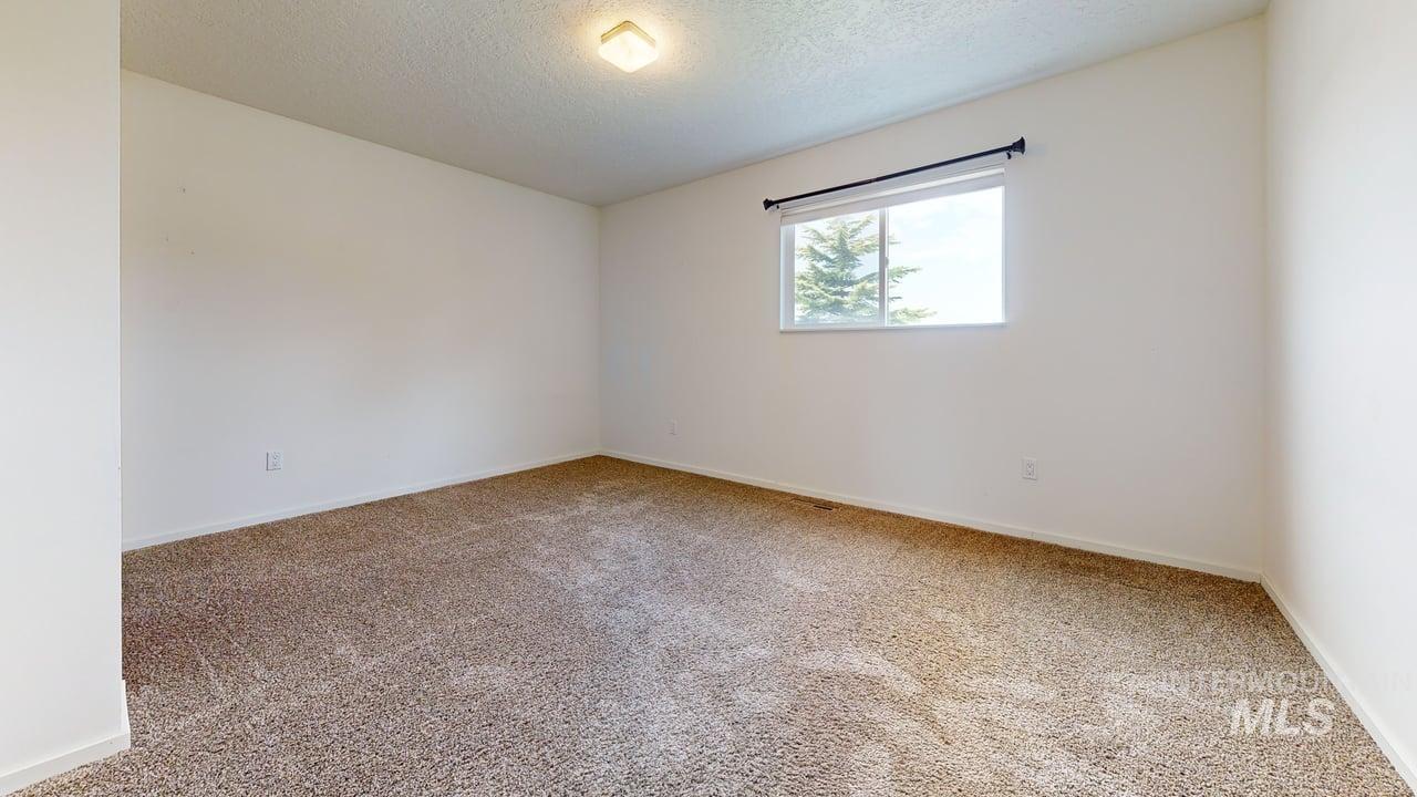 Spare room featuring light colored carpet and a textured ceiling