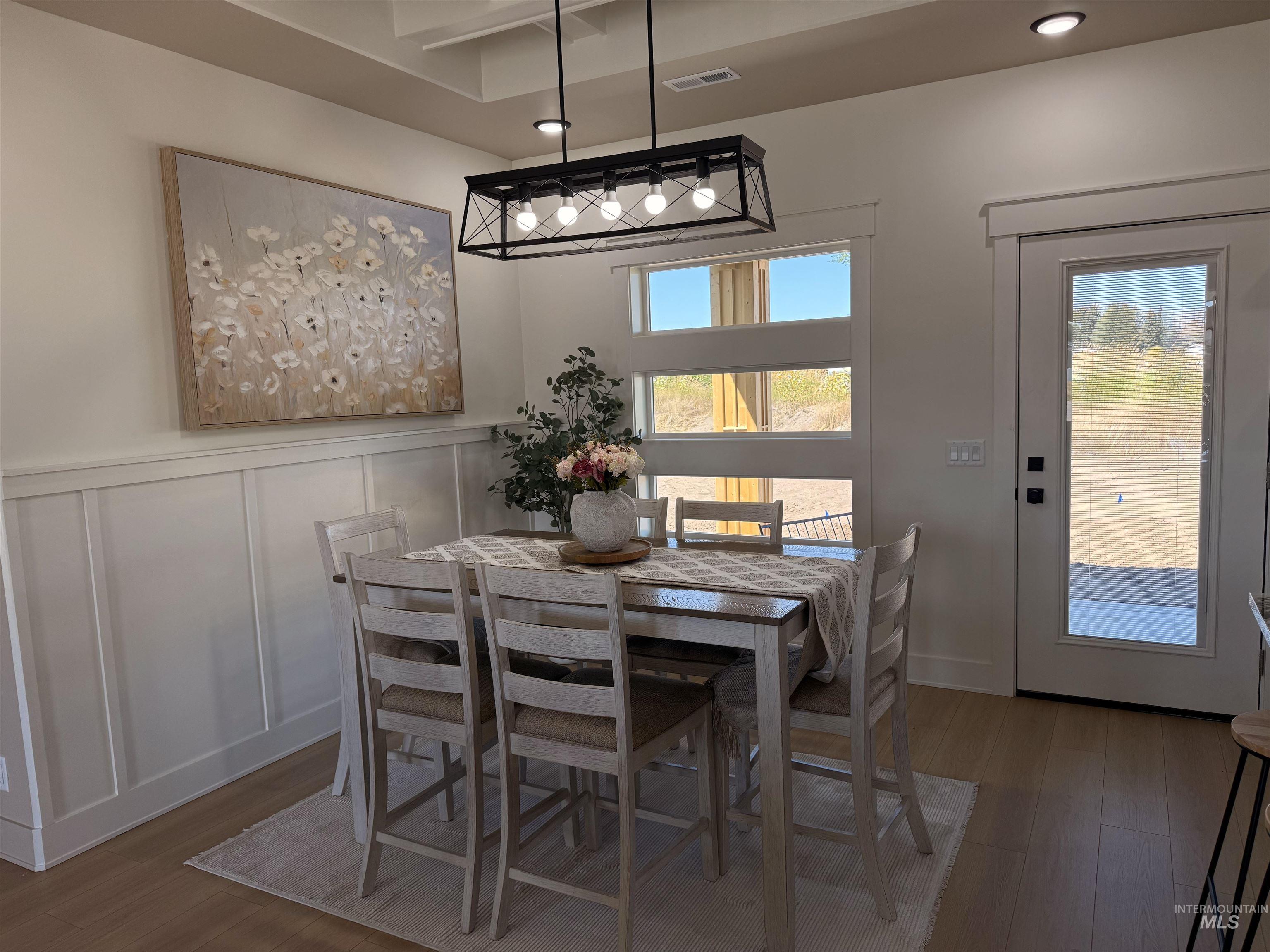 Dining room featuring dark wood finished floors, a decorative wall, and recessed lighting