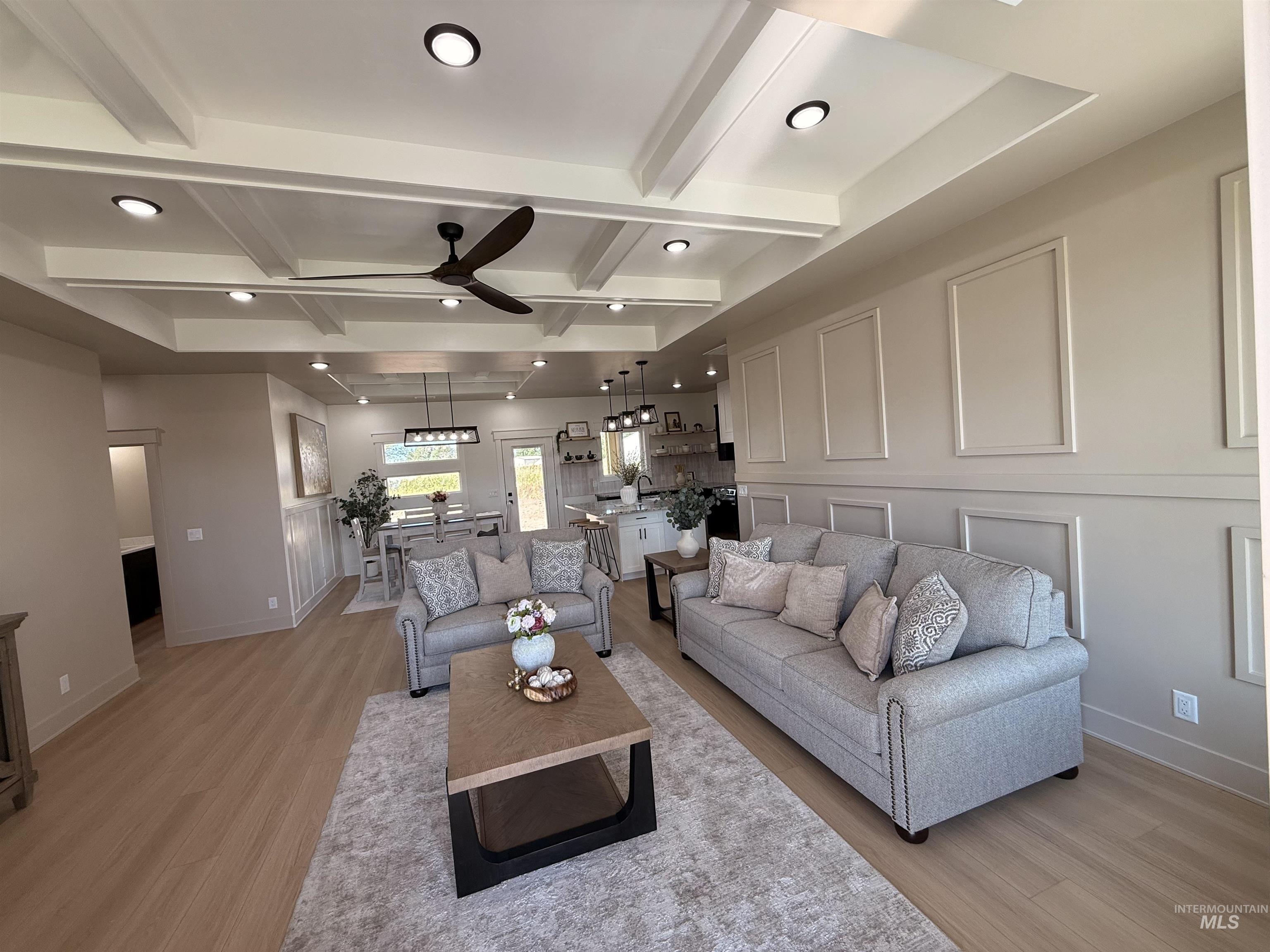 Living area with beamed ceiling, light wood-type flooring, recessed lighting, coffered ceiling, and a ceiling fan