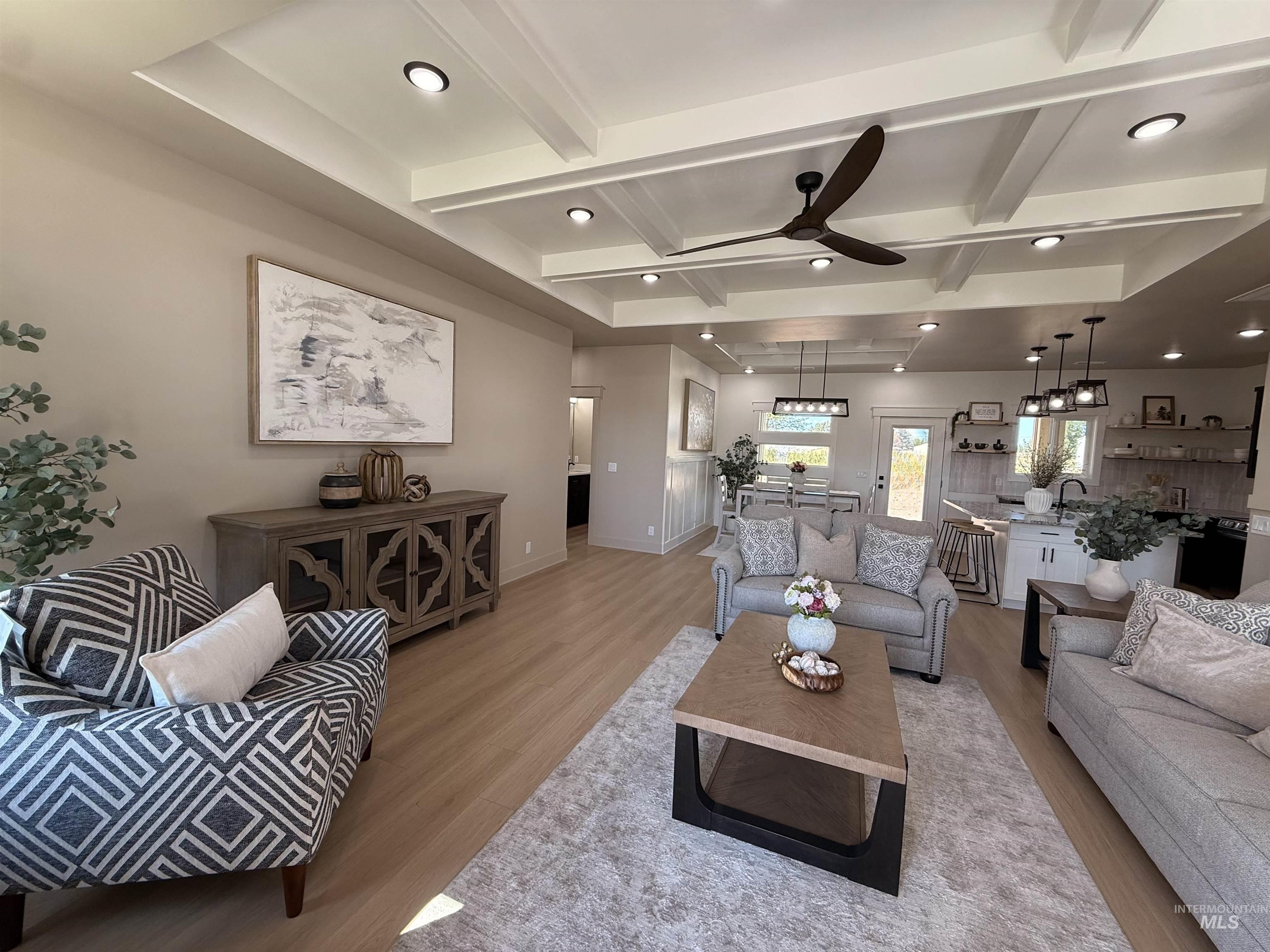 Living area with beam ceiling, wood finished floors, coffered ceiling, recessed lighting, and ceiling fan