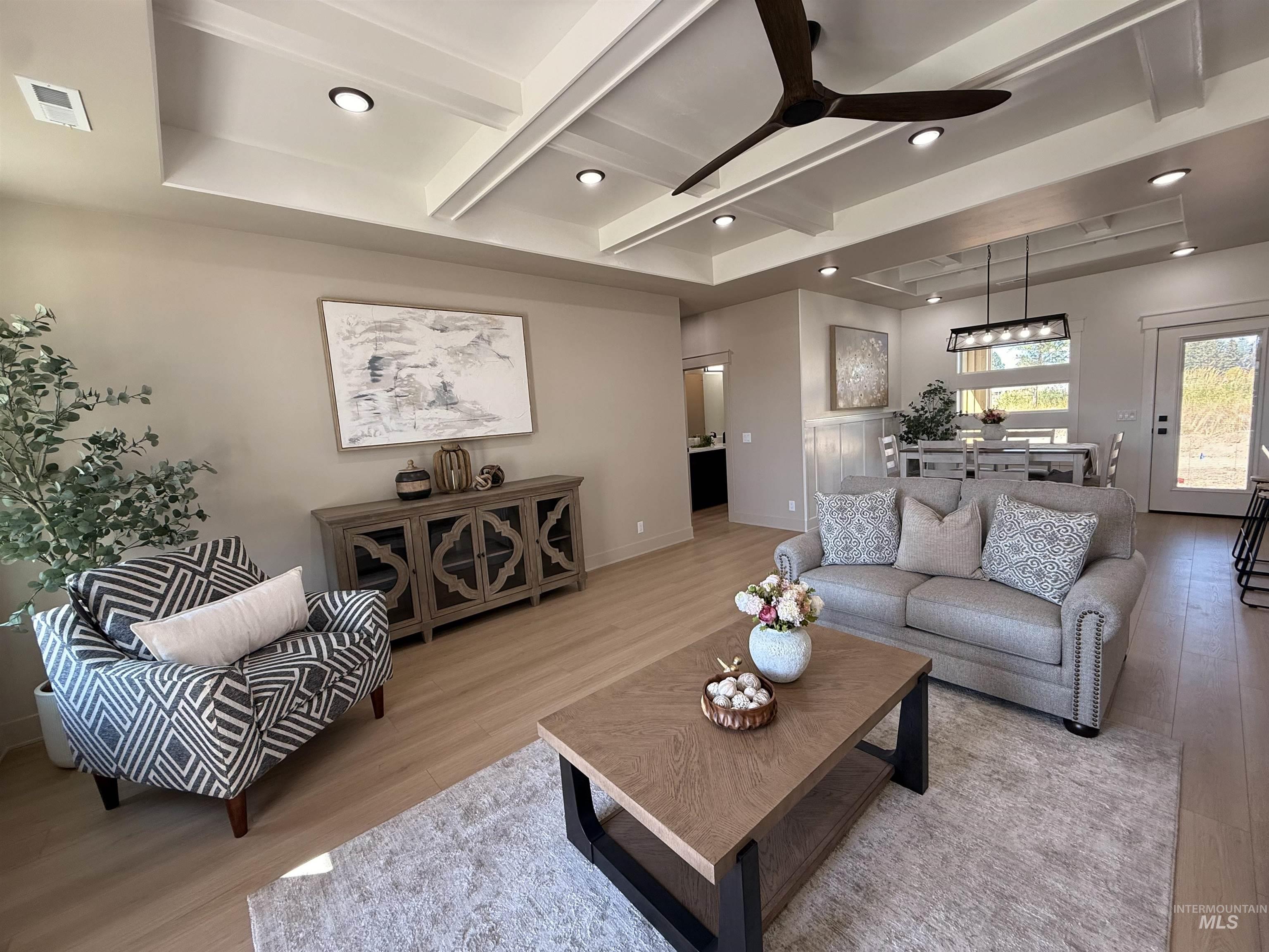 Living room featuring beam ceiling, wood finished floors, a ceiling fan, coffered ceiling, and recessed lighting