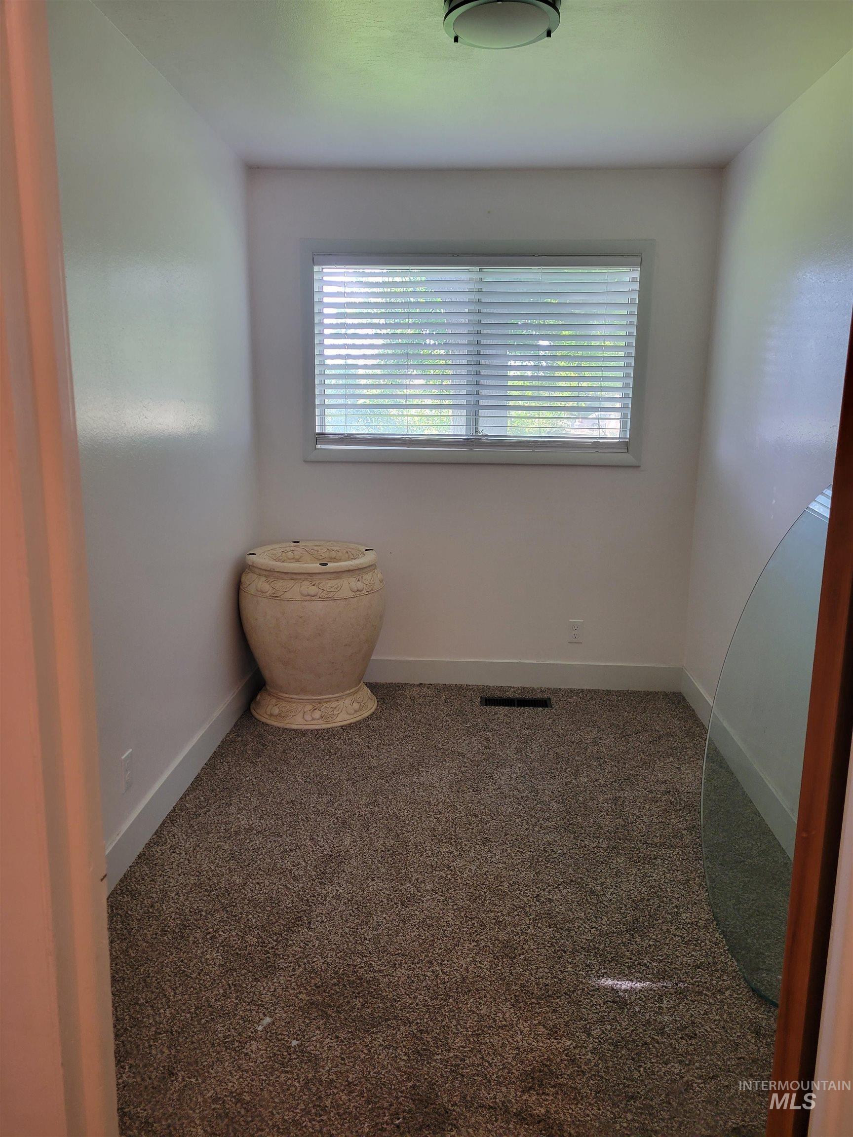 Carpeted empty room with baseboards