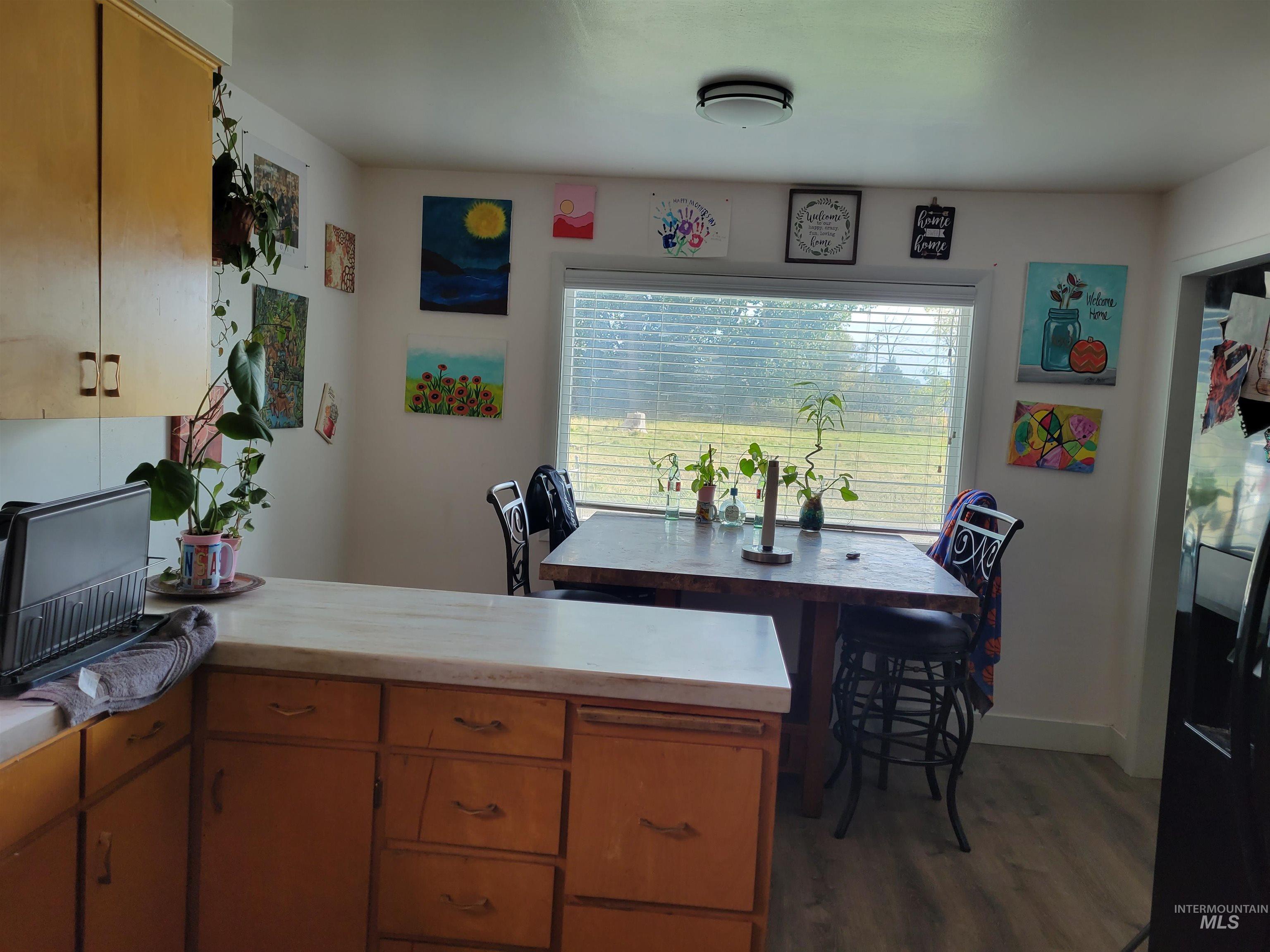 Kitchen with stainless steel fridge, light countertops, dark wood-style floors, and a peninsula