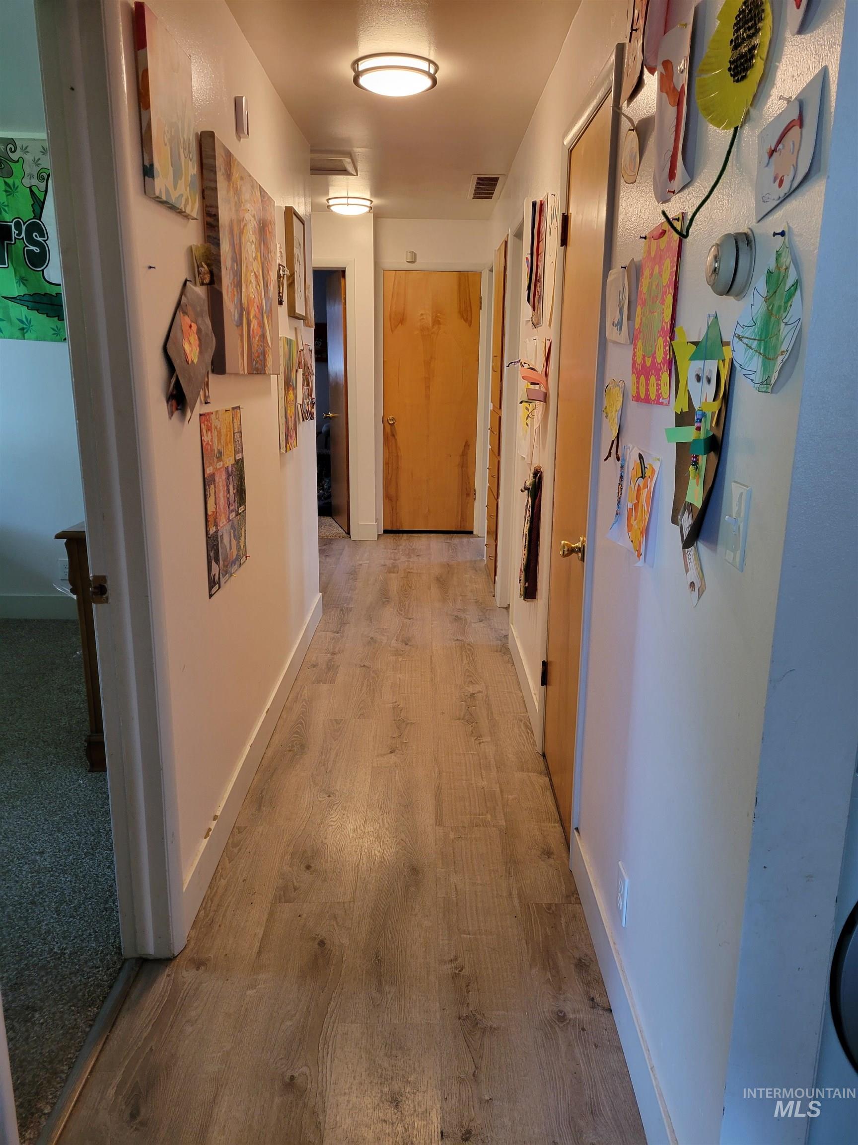 Hallway featuring wood finished floors and baseboards
