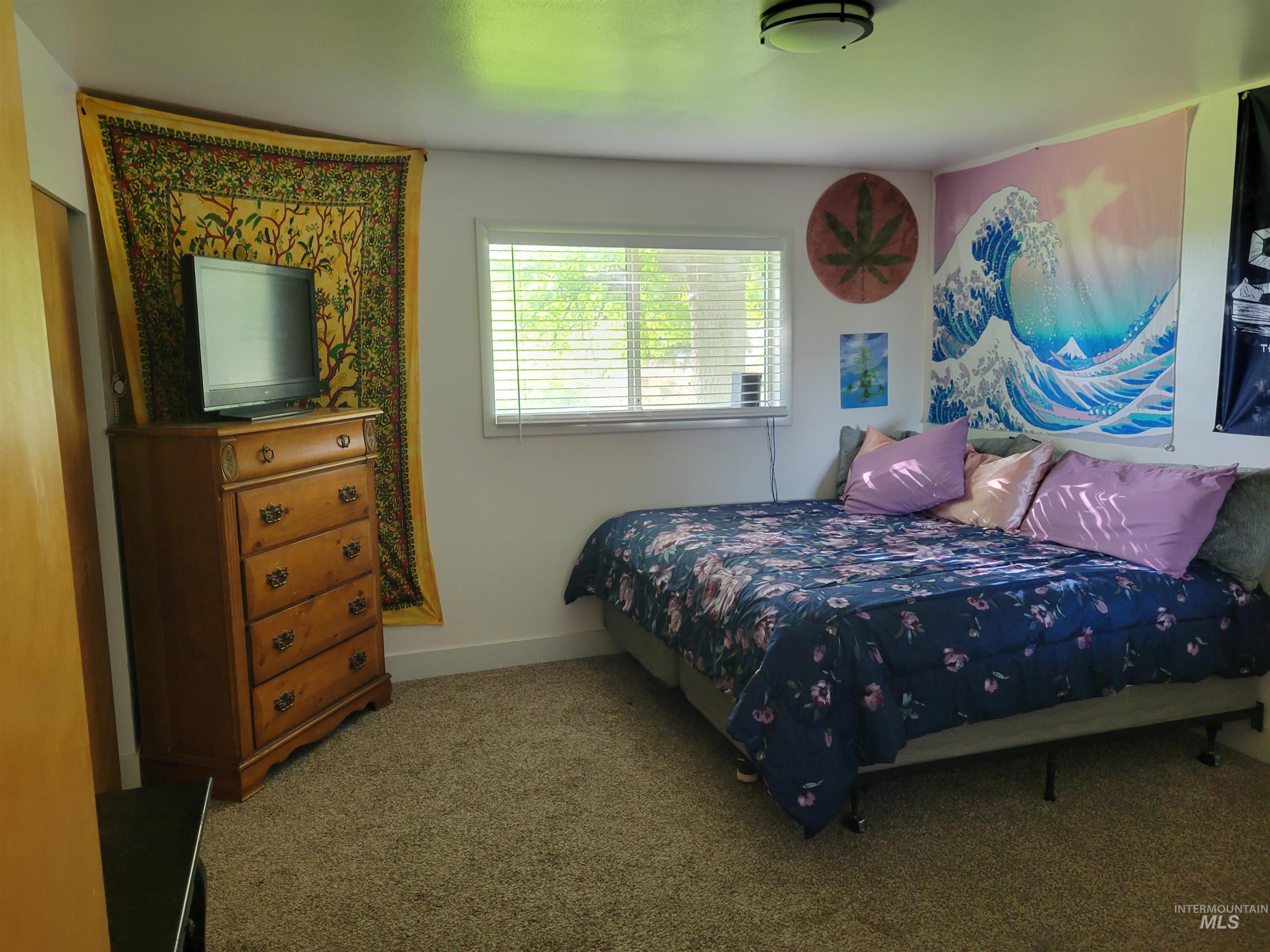 Bedroom featuring carpet and baseboards