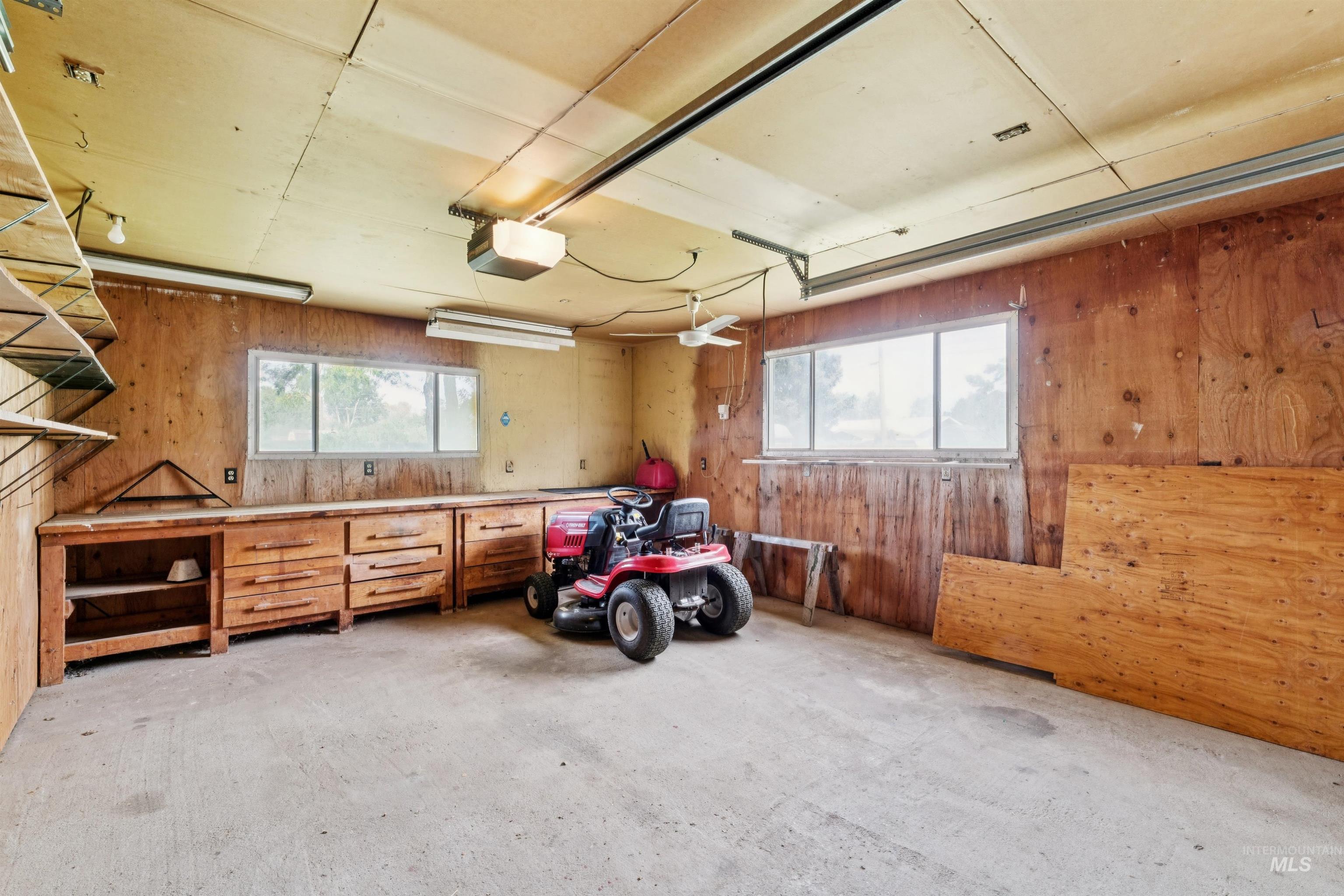 Garage with wood walls and a garage door opener