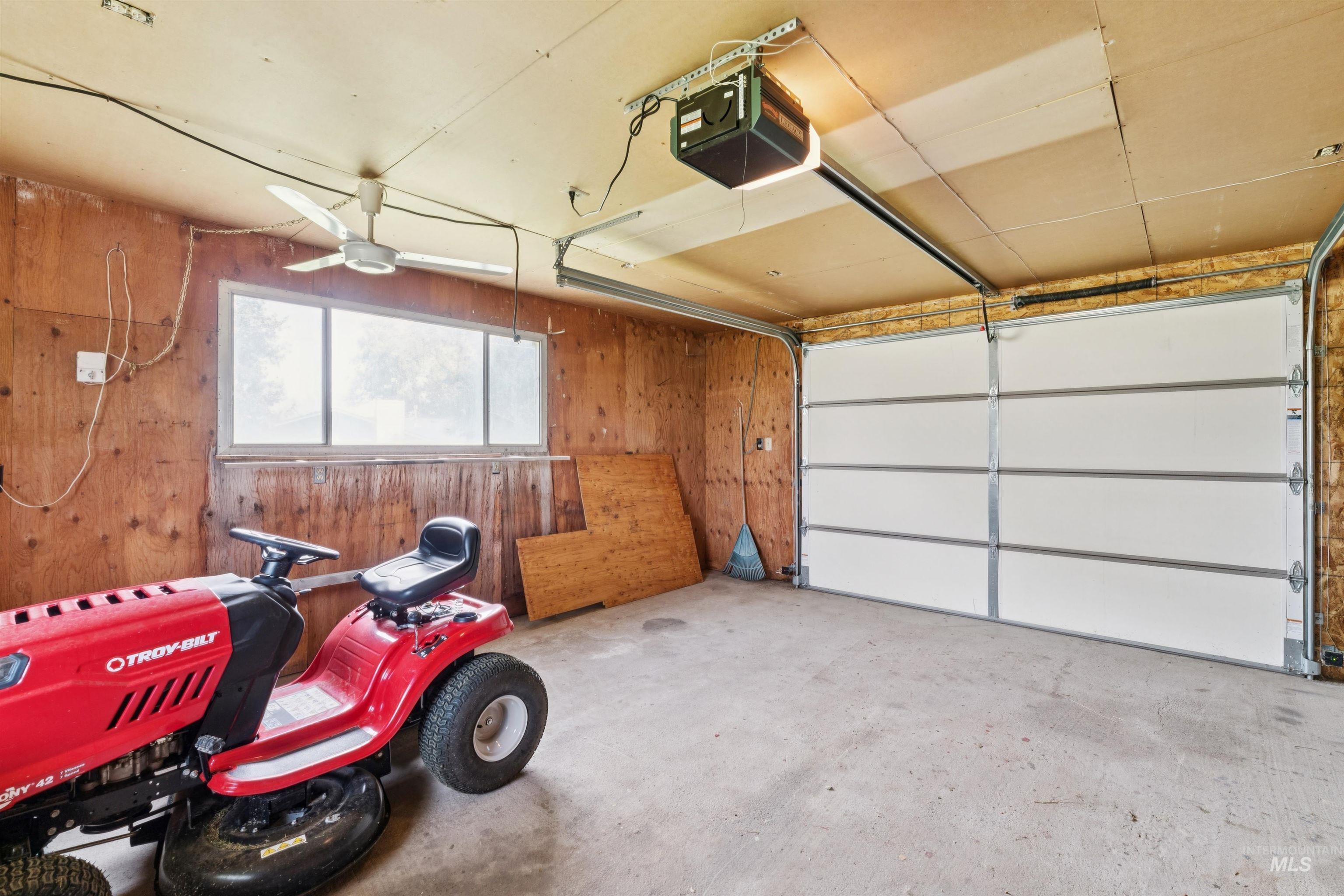 Garage with a garage door opener and wooden walls