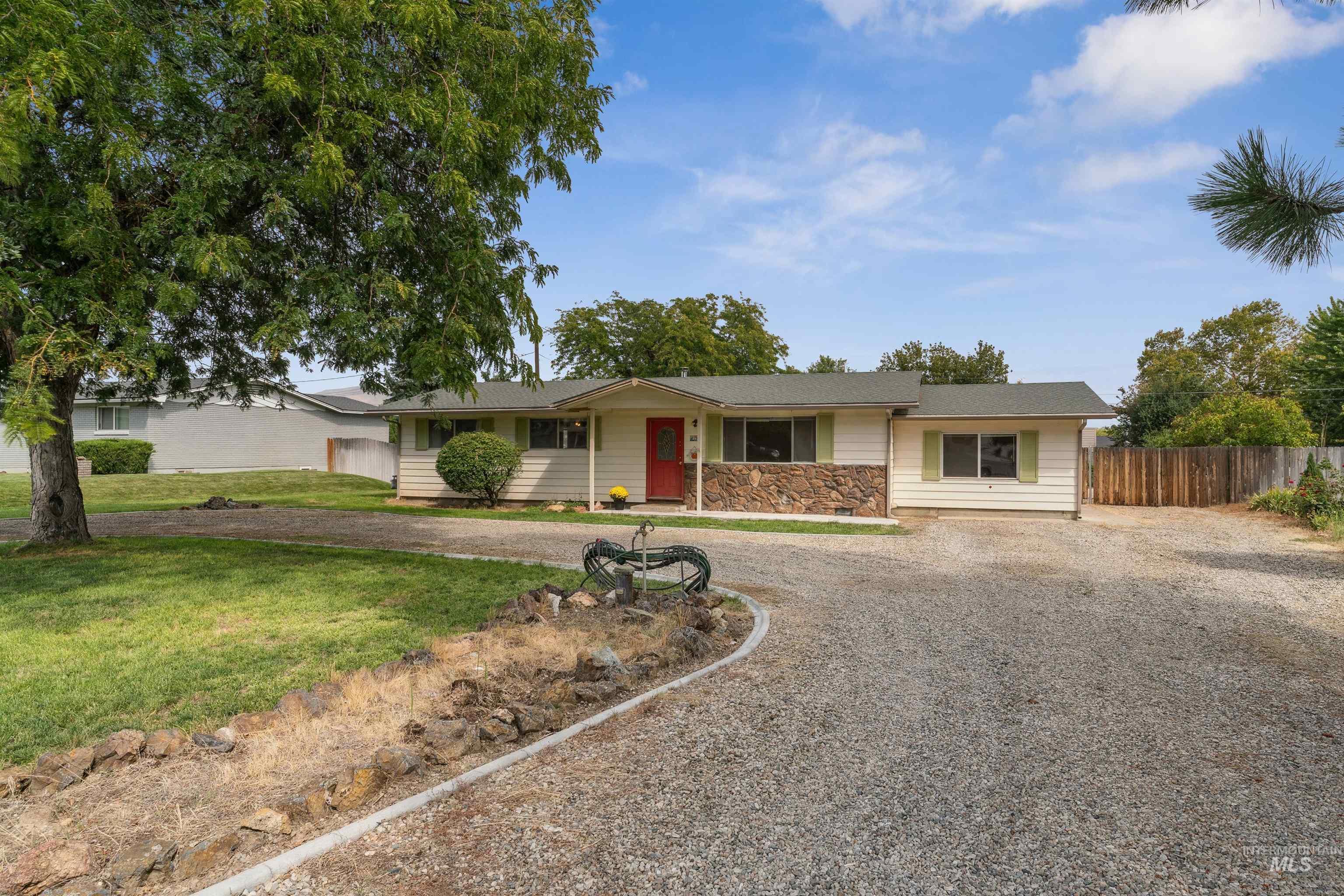 Ranch-style home with driveway and stone siding