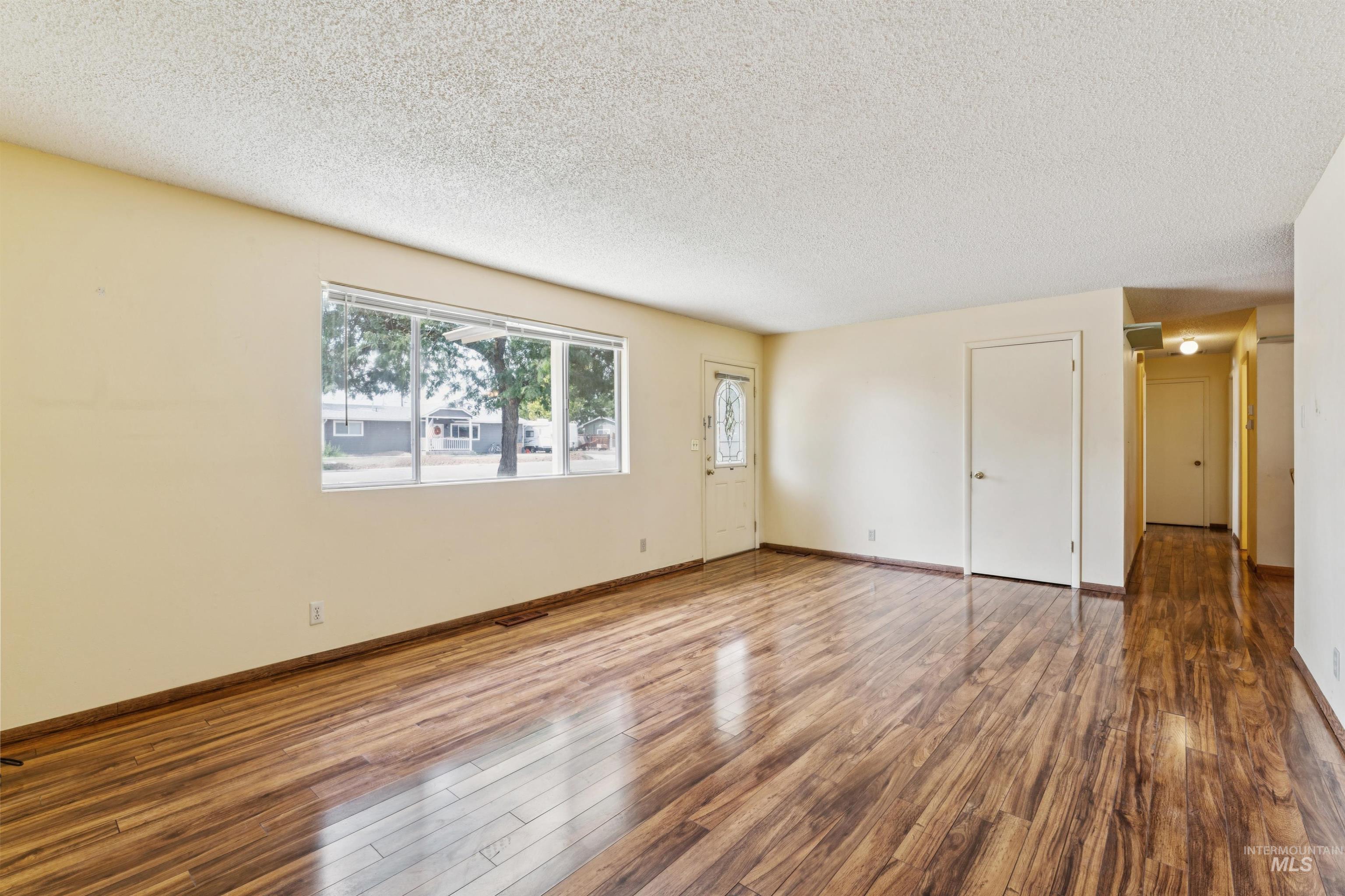 Unfurnished room featuring hardwood / wood-style floors and a textured ceiling