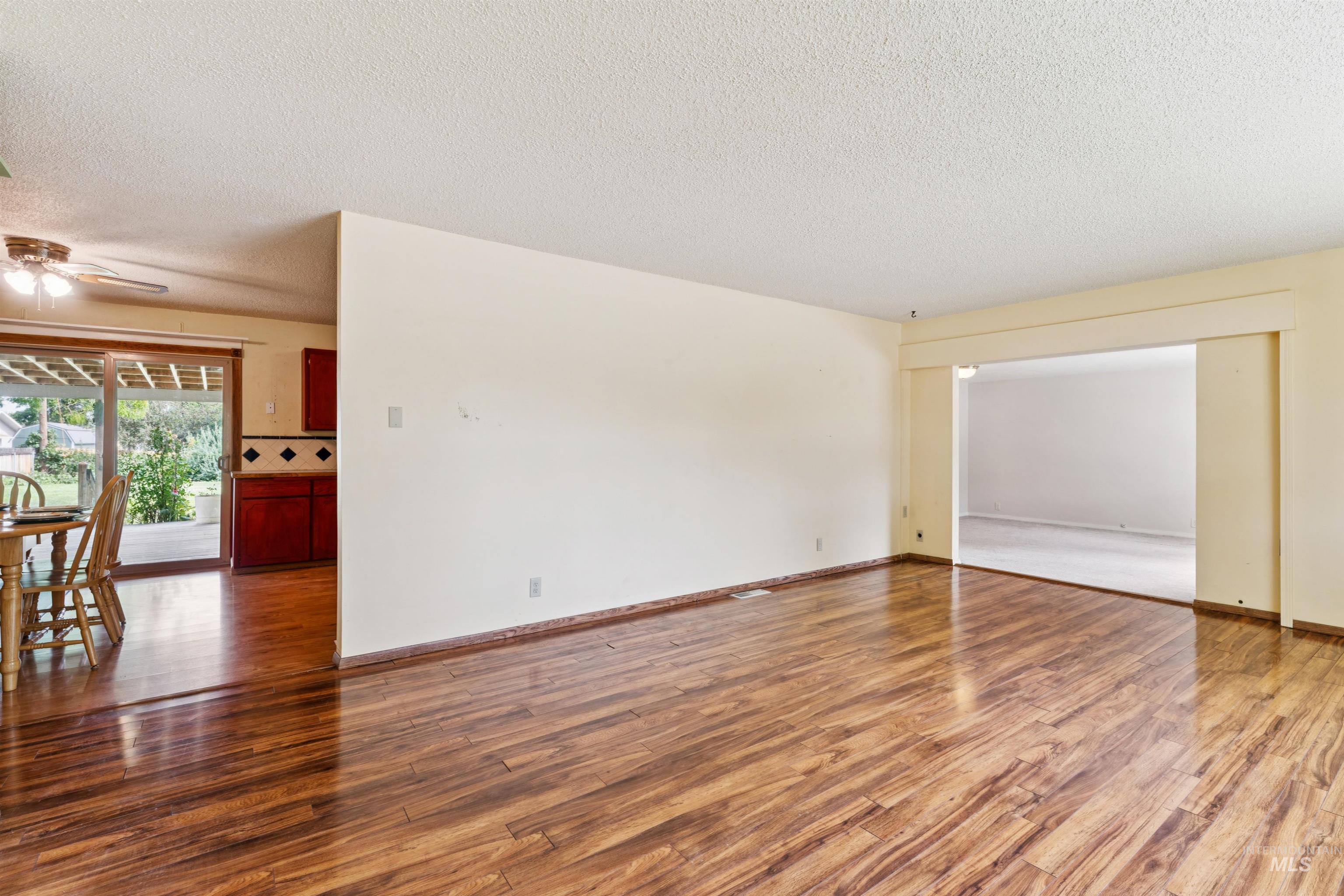 Unfurnished room featuring wood finished floors, a textured ceiling, and ceiling fan
