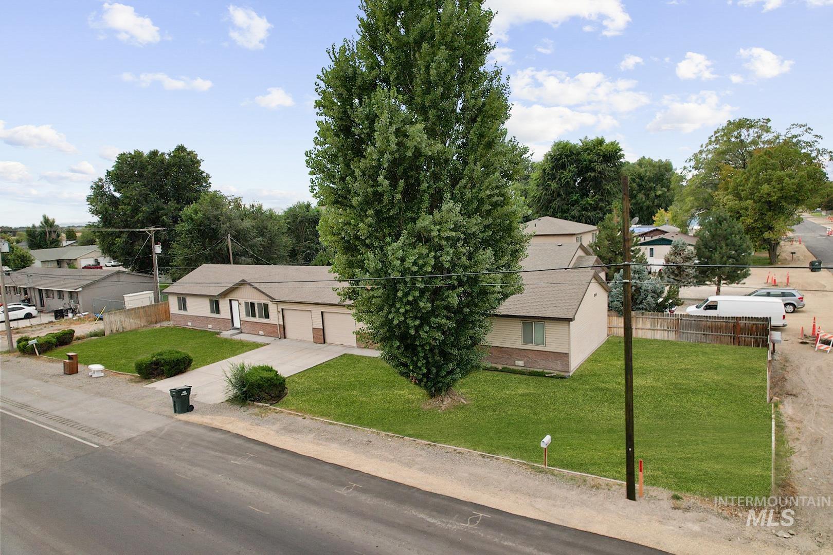 View of front of property featuring brick siding, a garage, and driveway