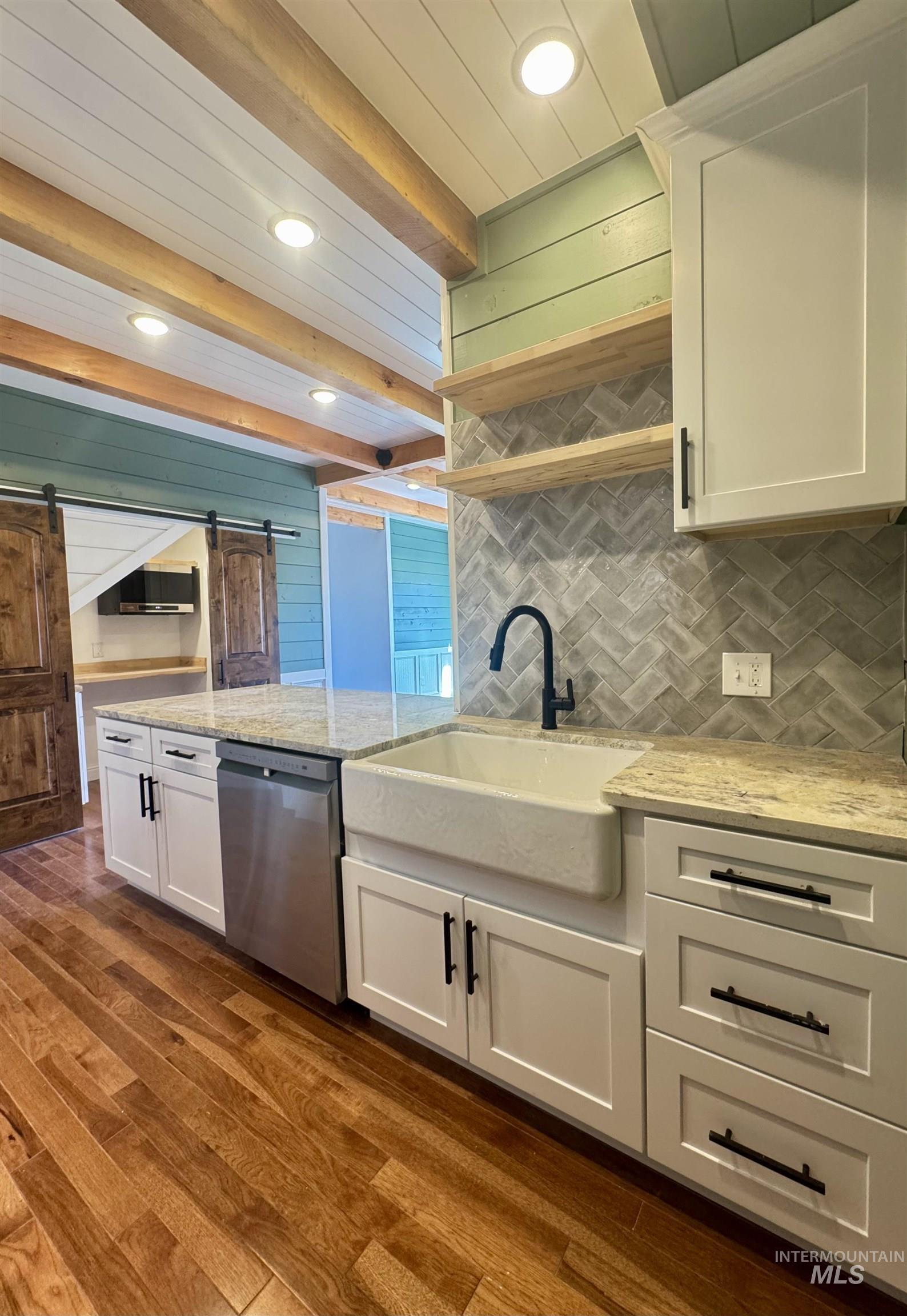 Kitchen with white cabinetry, light stone countertops, decorative backsplash, dark wood-style flooring, and recessed lighting