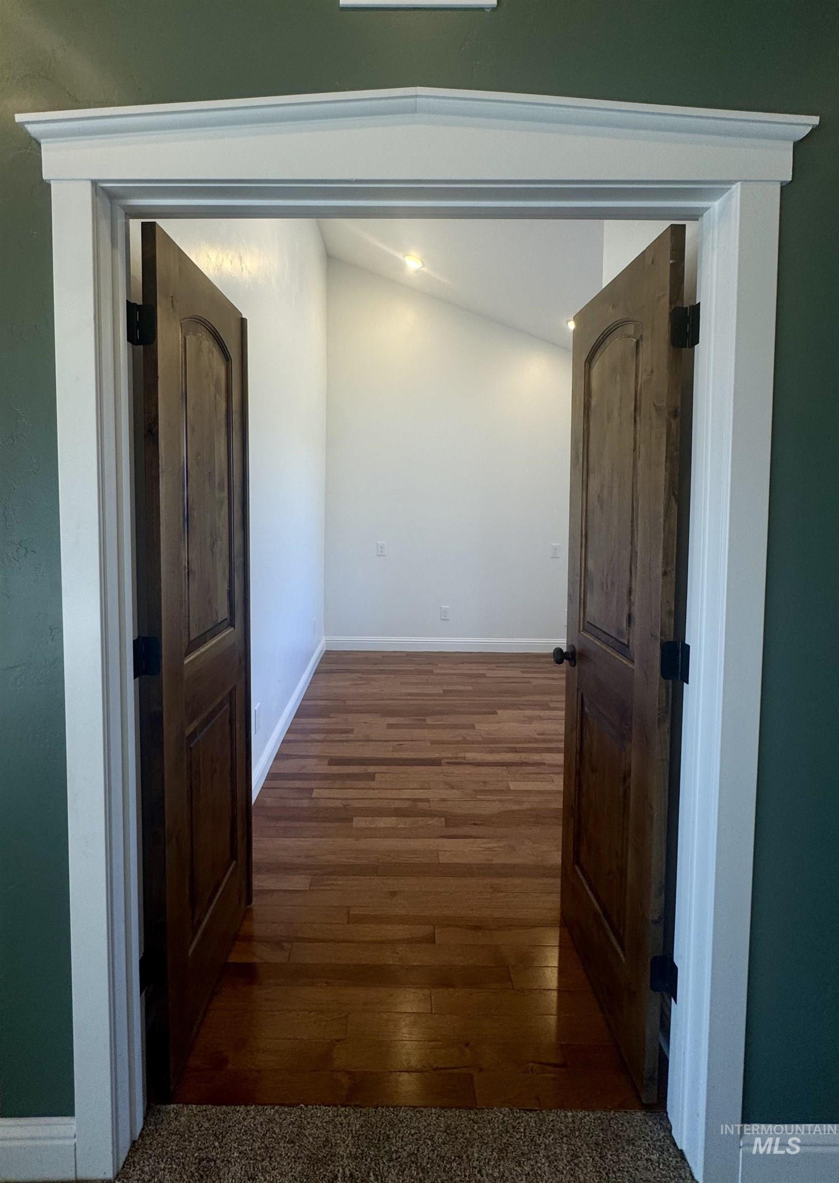Corridor with baseboards and dark wood-type flooring