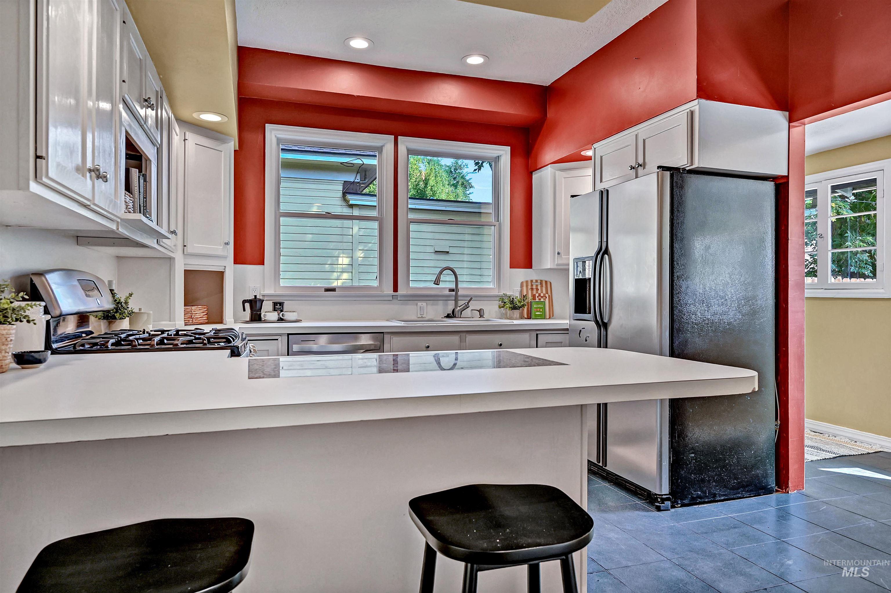 Kitchen featuring a peninsula, stainless steel appliances, a kitchen breakfast bar, plenty of natural light, and recessed lighting