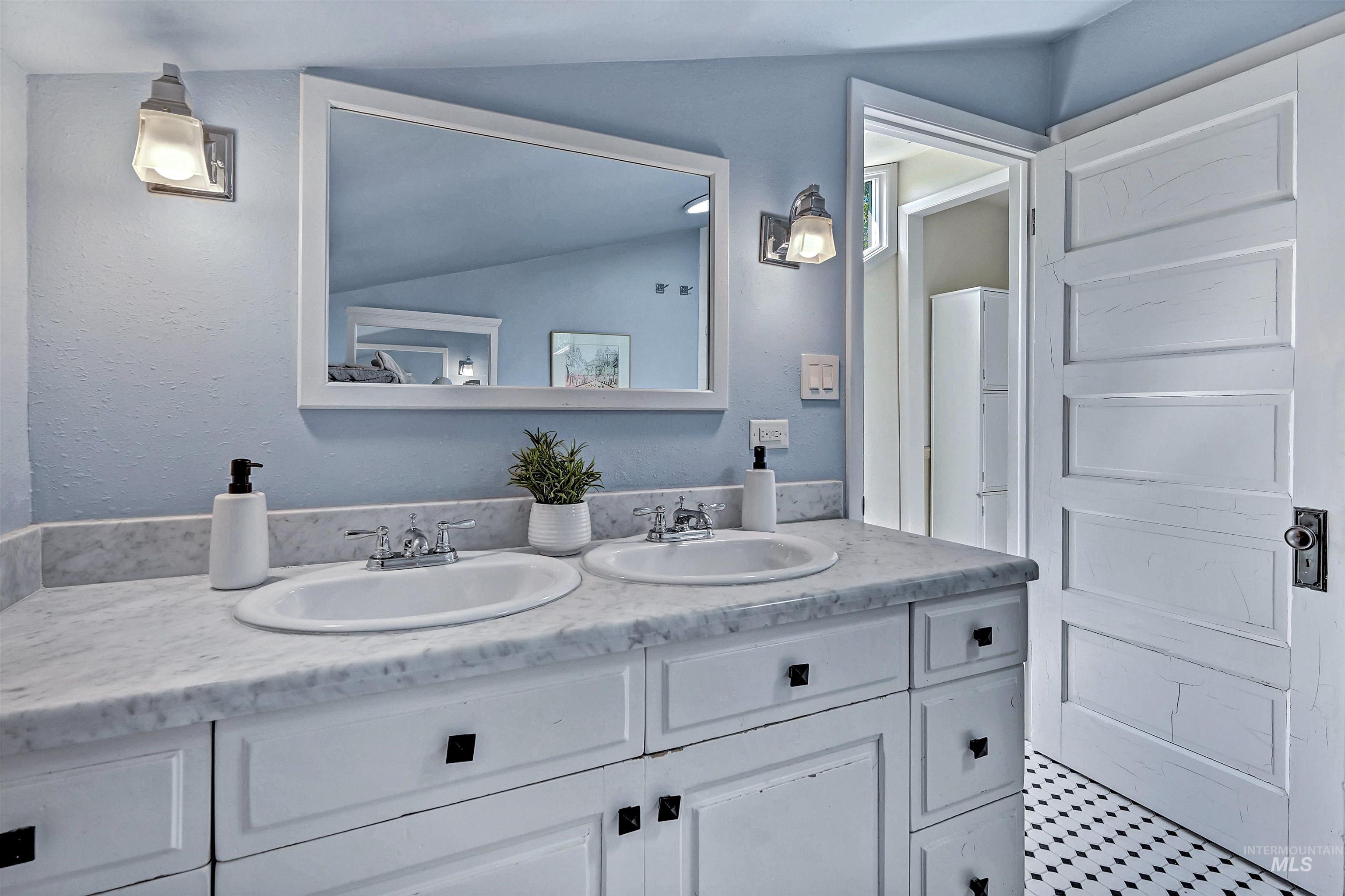 Full bath featuring double vanity and walk-in shower