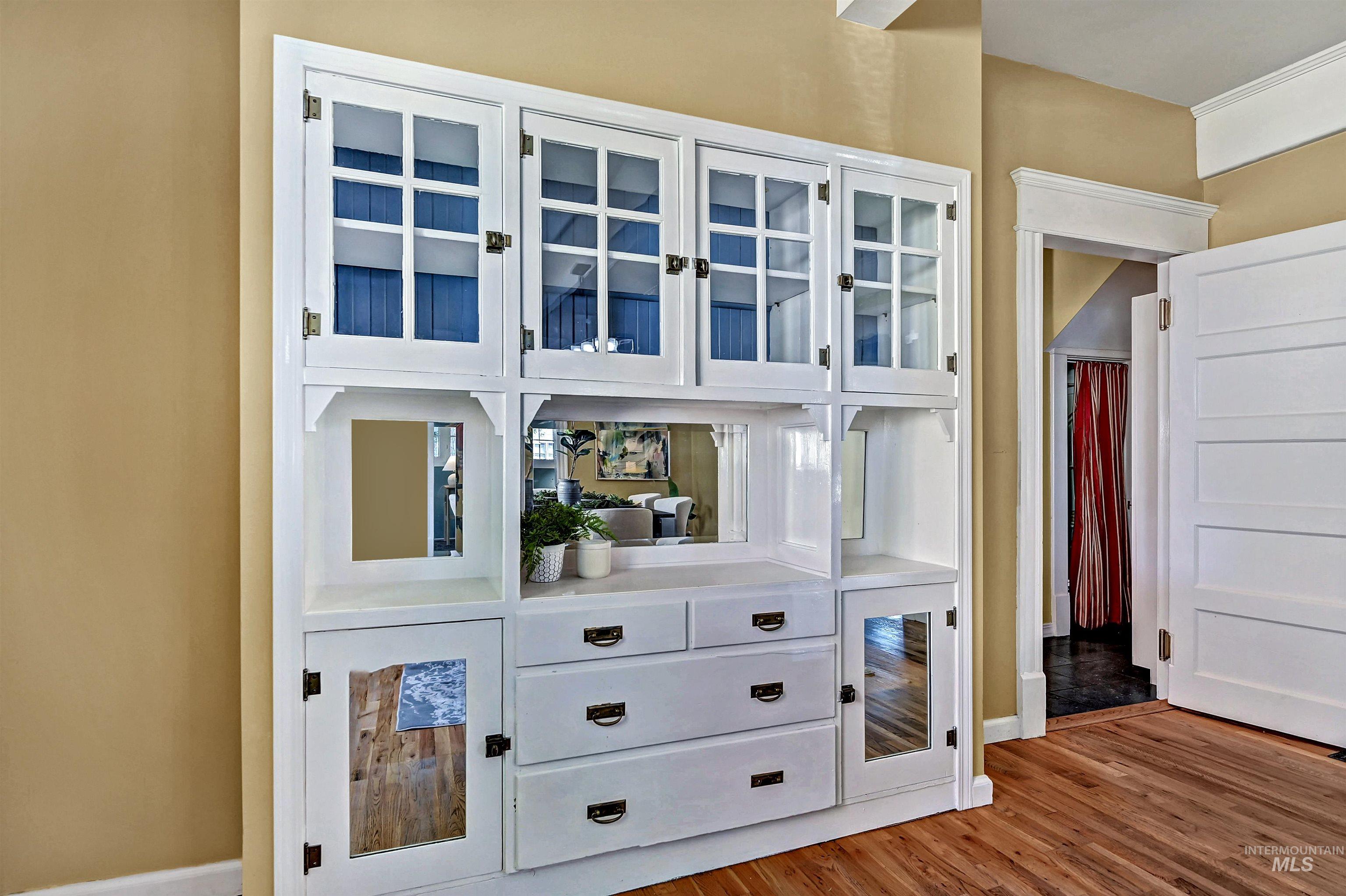 Built-in cabinets with glass-fronted doors & drawers for storage.