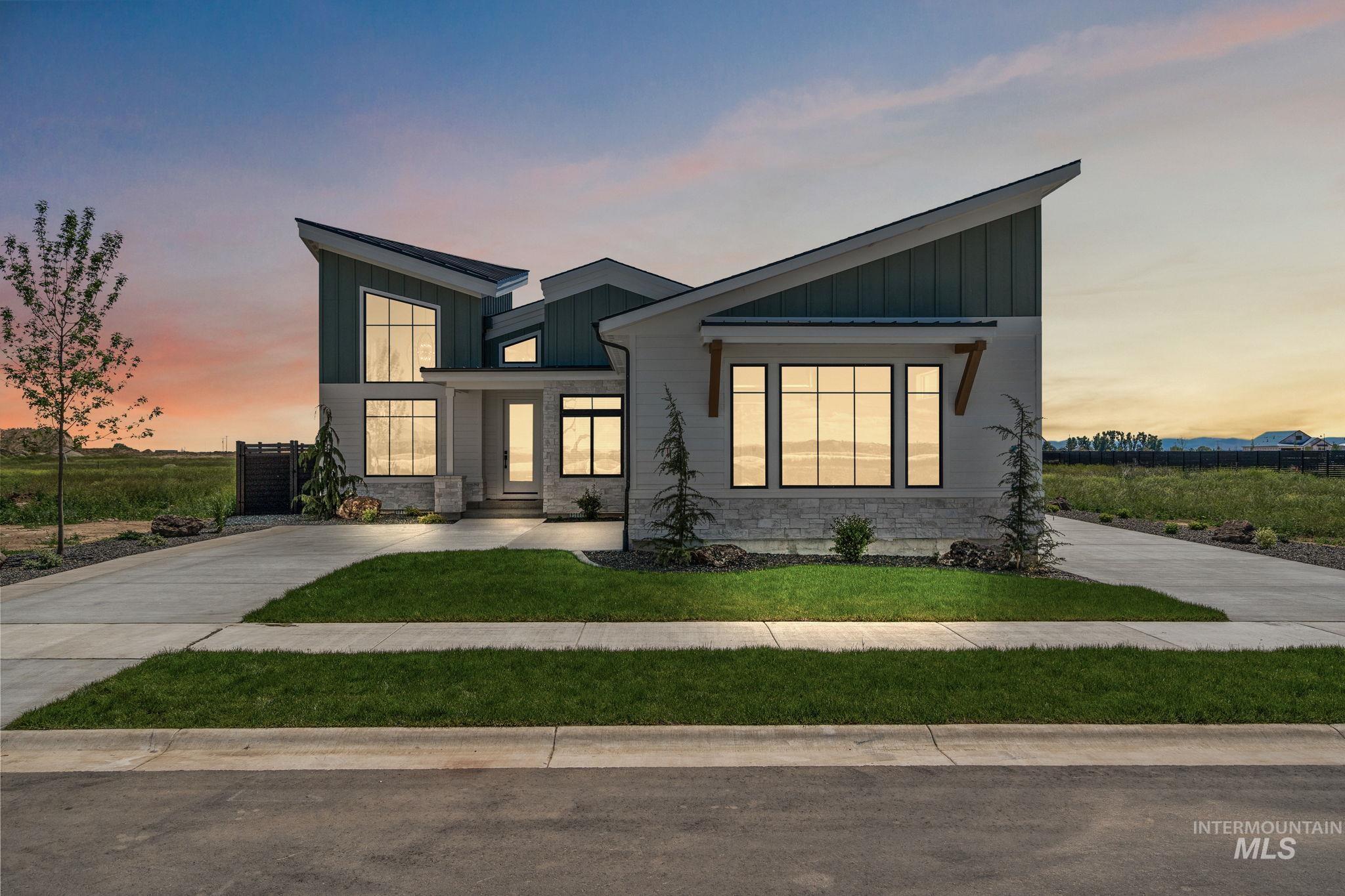 View of front of house with board and batten siding, stone siding, and a lawn
